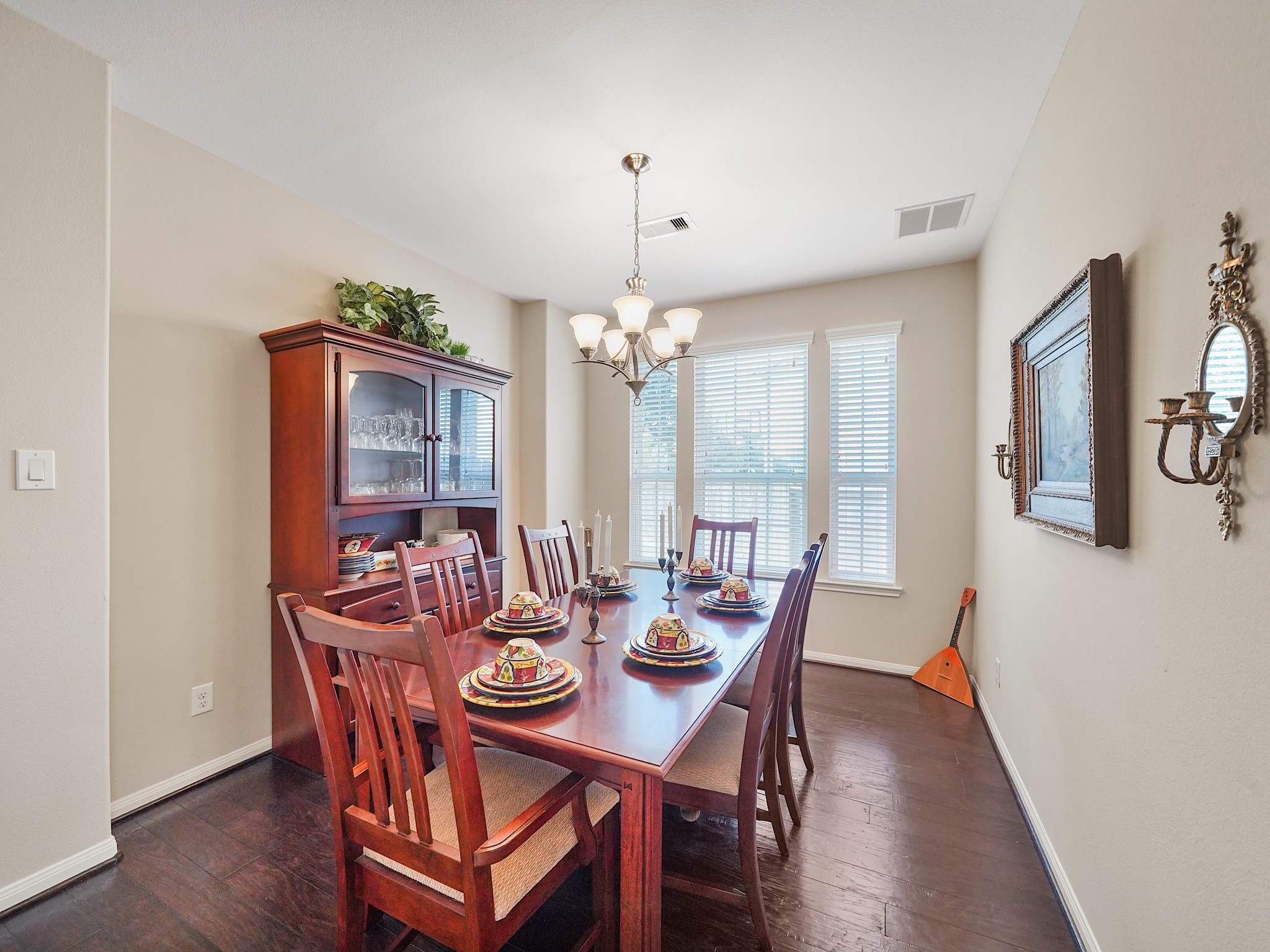 Rich wood flooring and natural light from the large windows bring warmth to the dining room, while a chandelier adds a touch of elegance. Its an inviting setting for intimate dinners, holiday gatherings, and celebrations with those you love.