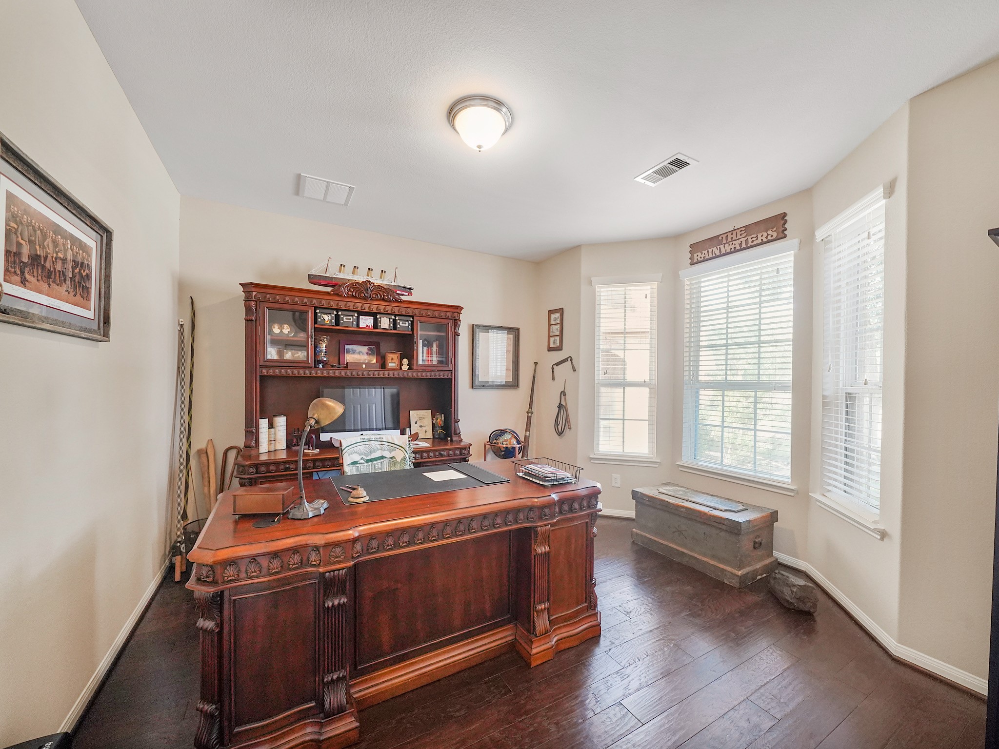 Discover the perfect blend of elegance and functionality in this private office, featuring rich wood flooring and ample natural light for an inspiring workspace.