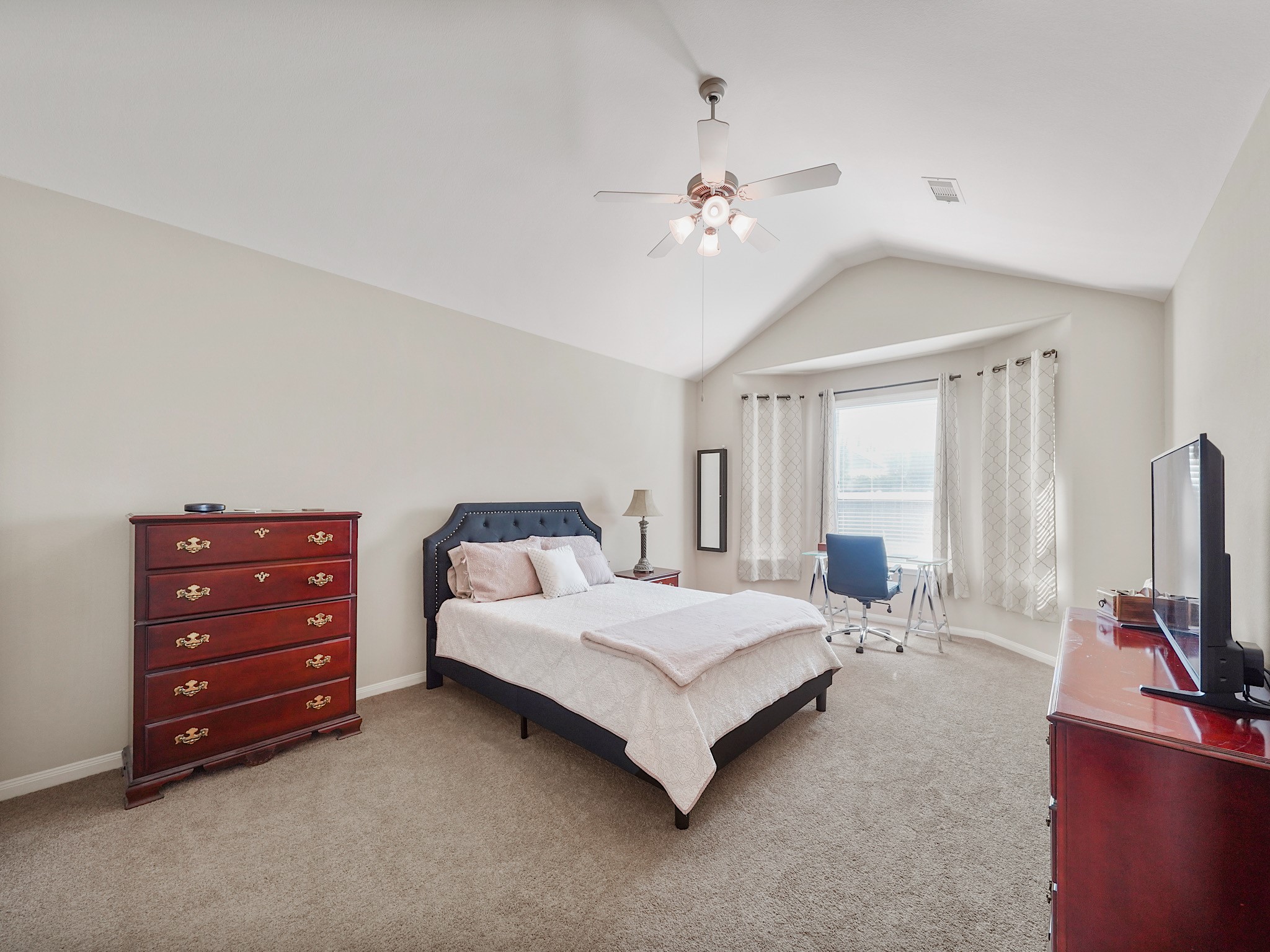 A vaulted ceiling and abundant natural light give the primary retreat an airy, peaceful feel. The spacious room offers a welcoming place to begin the morning and unwind at the end of the day.