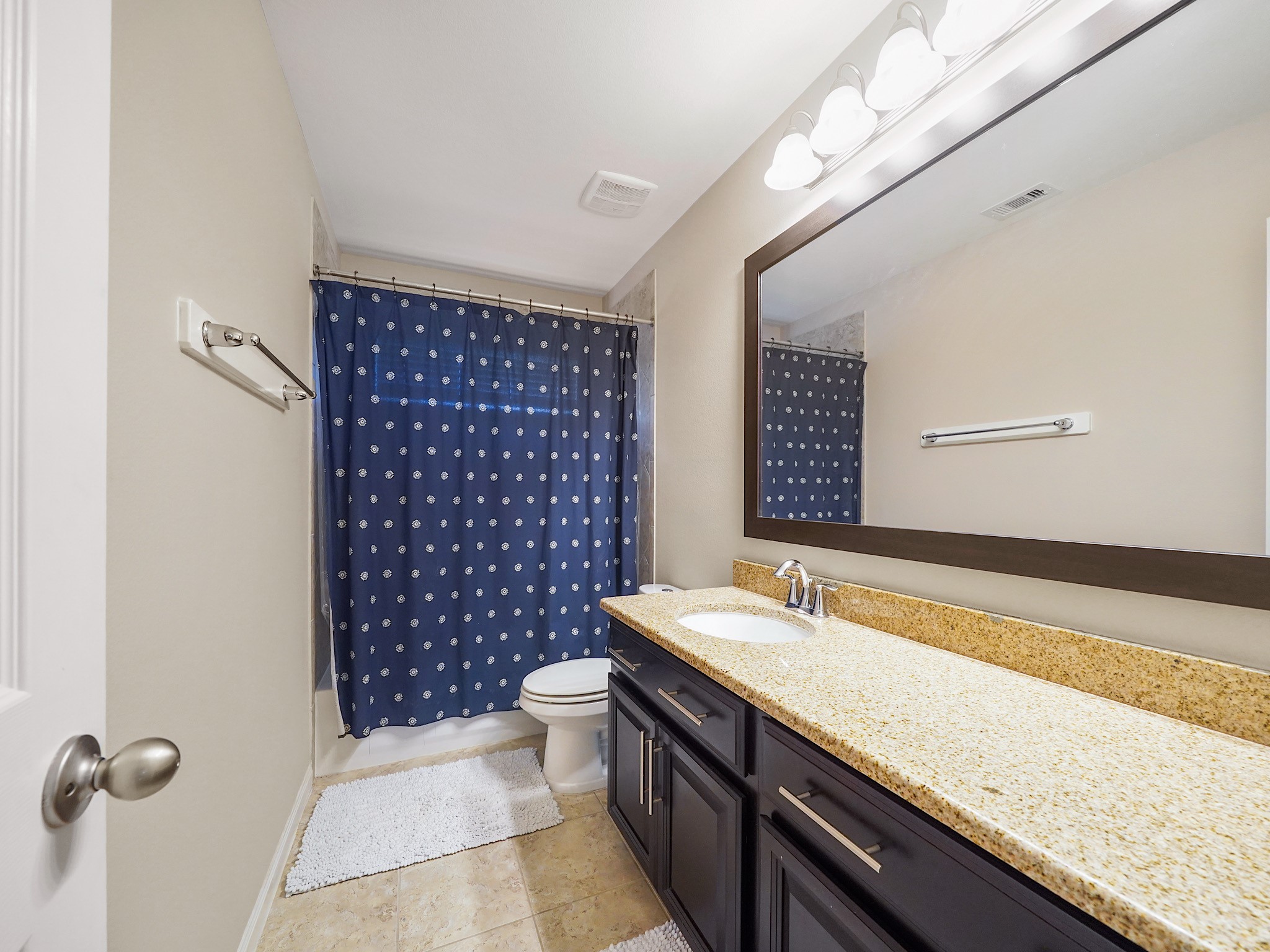 The upstairs secondary bathroom features an extended vanity with extra storage to keep everyday essentials organized and within reach. A tub and shower combination adds versatility for busy mornings and relaxing evenings alike.