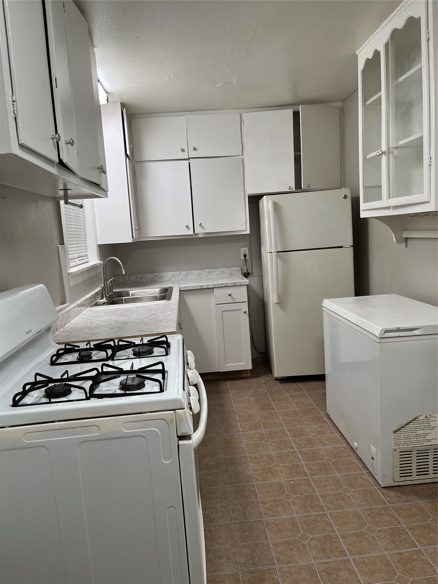 Kitchen showing, gas stove, freezer, new lower cabinets, refrigerator with lots of storage.