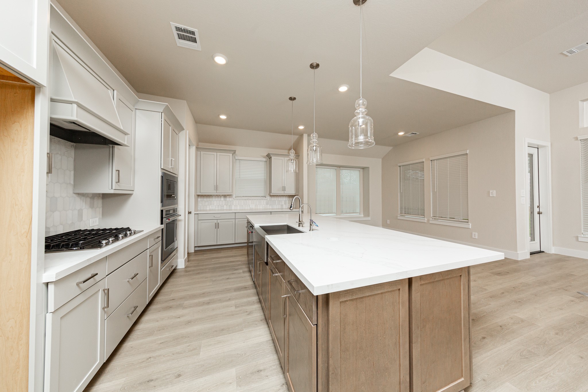 Discover the perfect blend of style and function in this modern kitchen, ready for your next culinary adventure. Equipped with high-end, stainless steel appliances, including a gas cooktop, built-in oven, and microwave.
