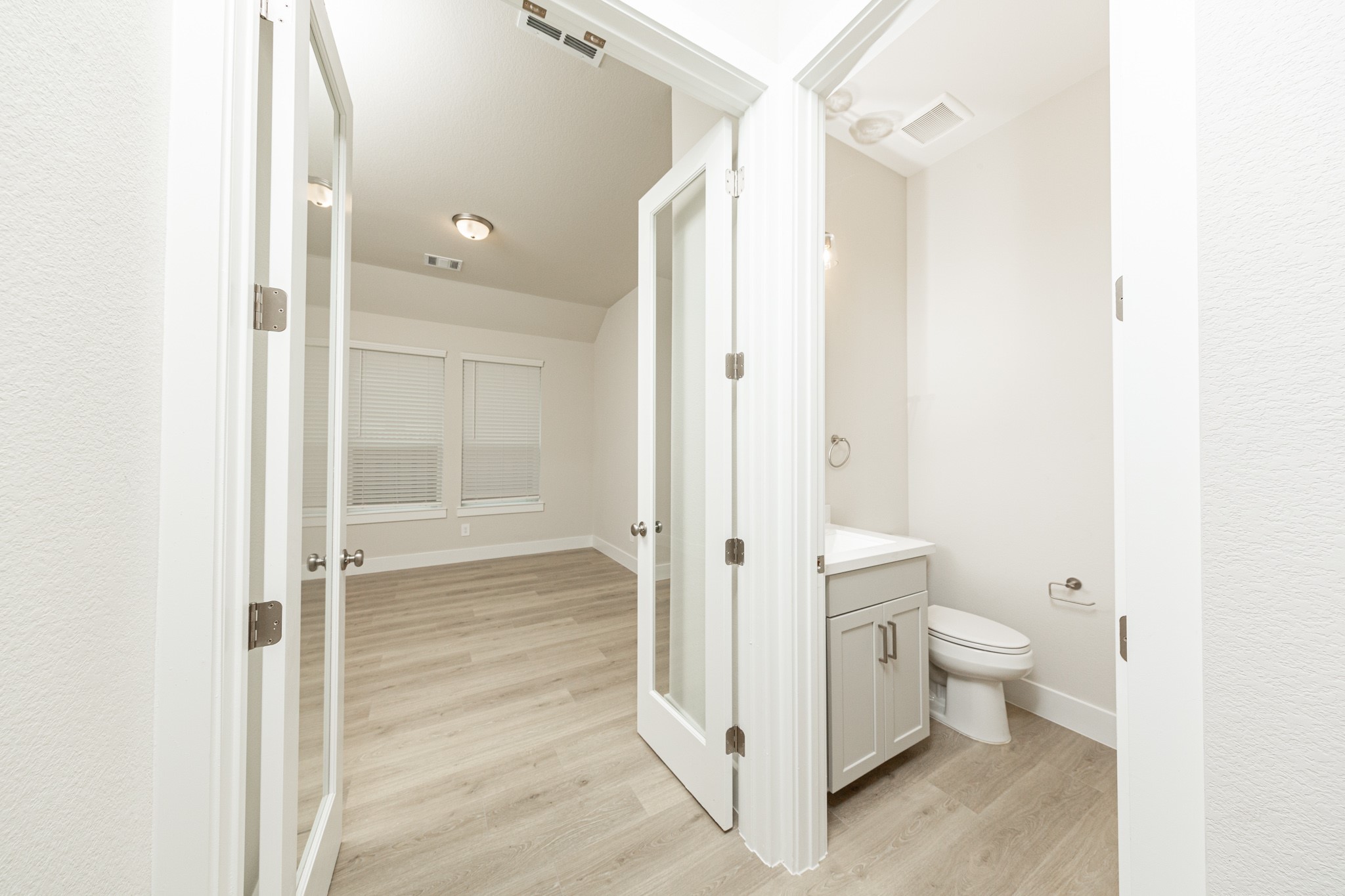 The powder bath is located conveniently near the study! The study features elegant glass French doors that allow natural light to flow seamlessly into the main living areas while maintaining quiet separation.