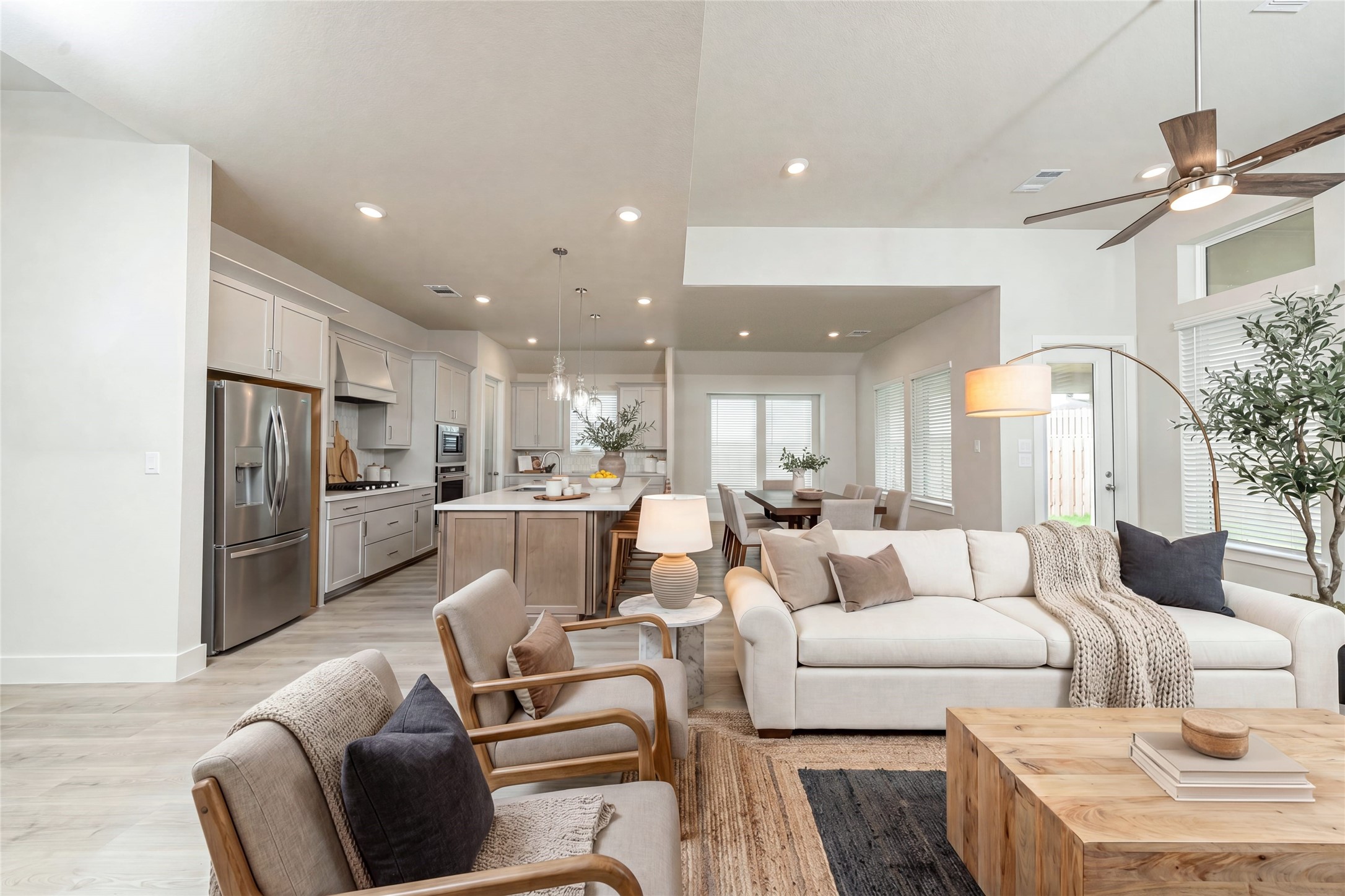 Open concept living with the living, kitchen and dining areas - all filled with natural light and featuring high ceilings, recessed lighting, and expansive windows. *Virtually Staged.