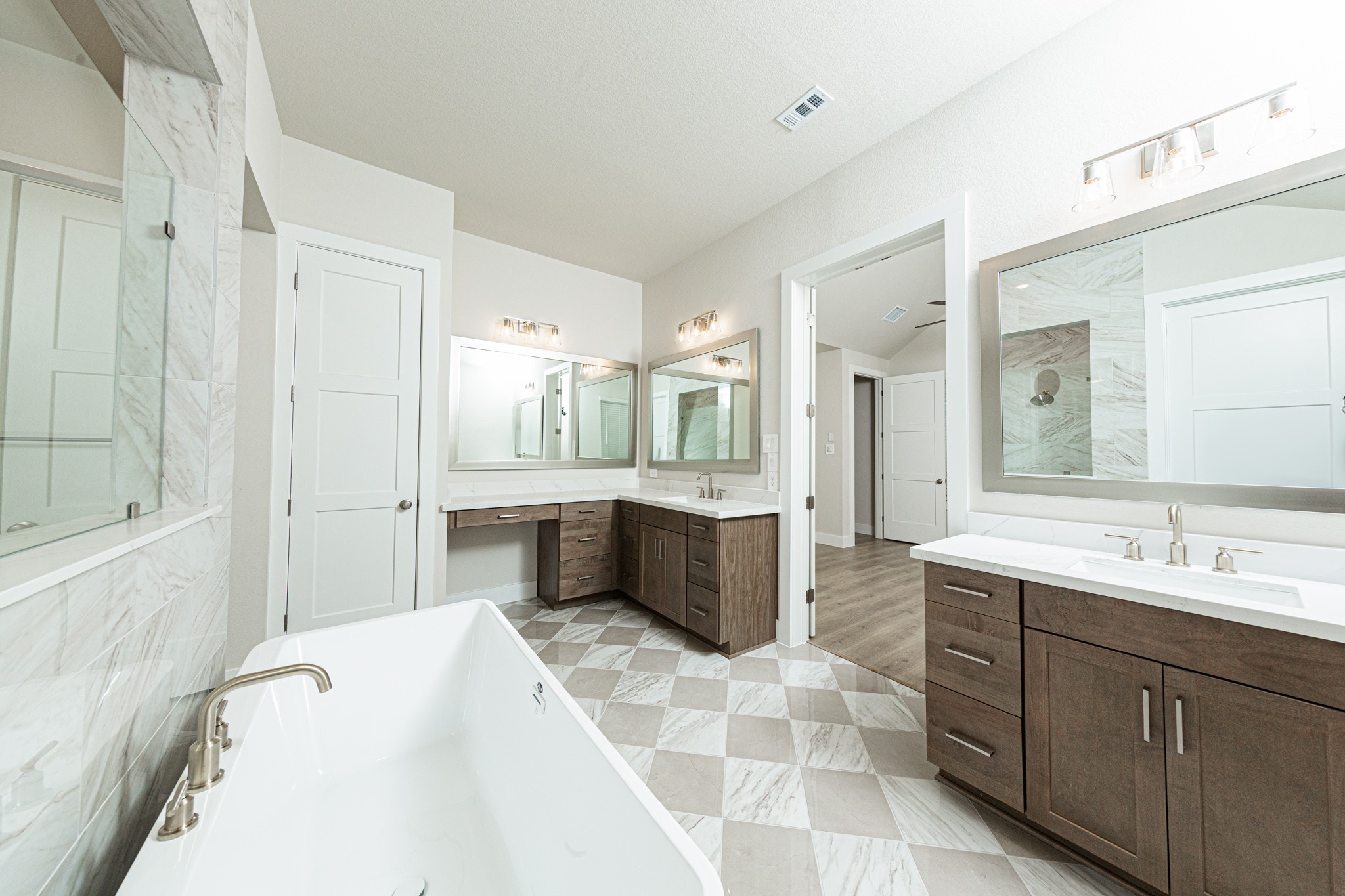 Additional view of dual vanities which also includes another vanity with knee space, allowing for a comfortable, seated grooming experience.
