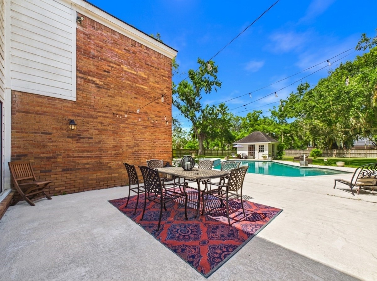 Back patio with sitting area looking at backyard and pool