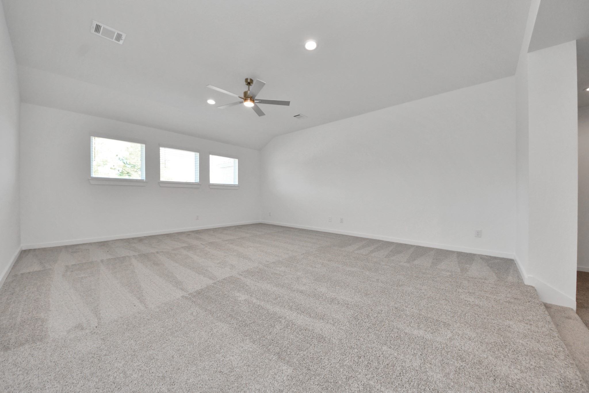 Discover a haven of leisure in this fantastic game room! Whether you're seeking a casual hangout or an adult gaming retreat, this space has it all. Enjoy the luxurious feel of plush carpet underfoot, the expansive ambiance of high ceilings, custom paint that adds a touch of personality, and windows that flood the room with refreshing natural light.