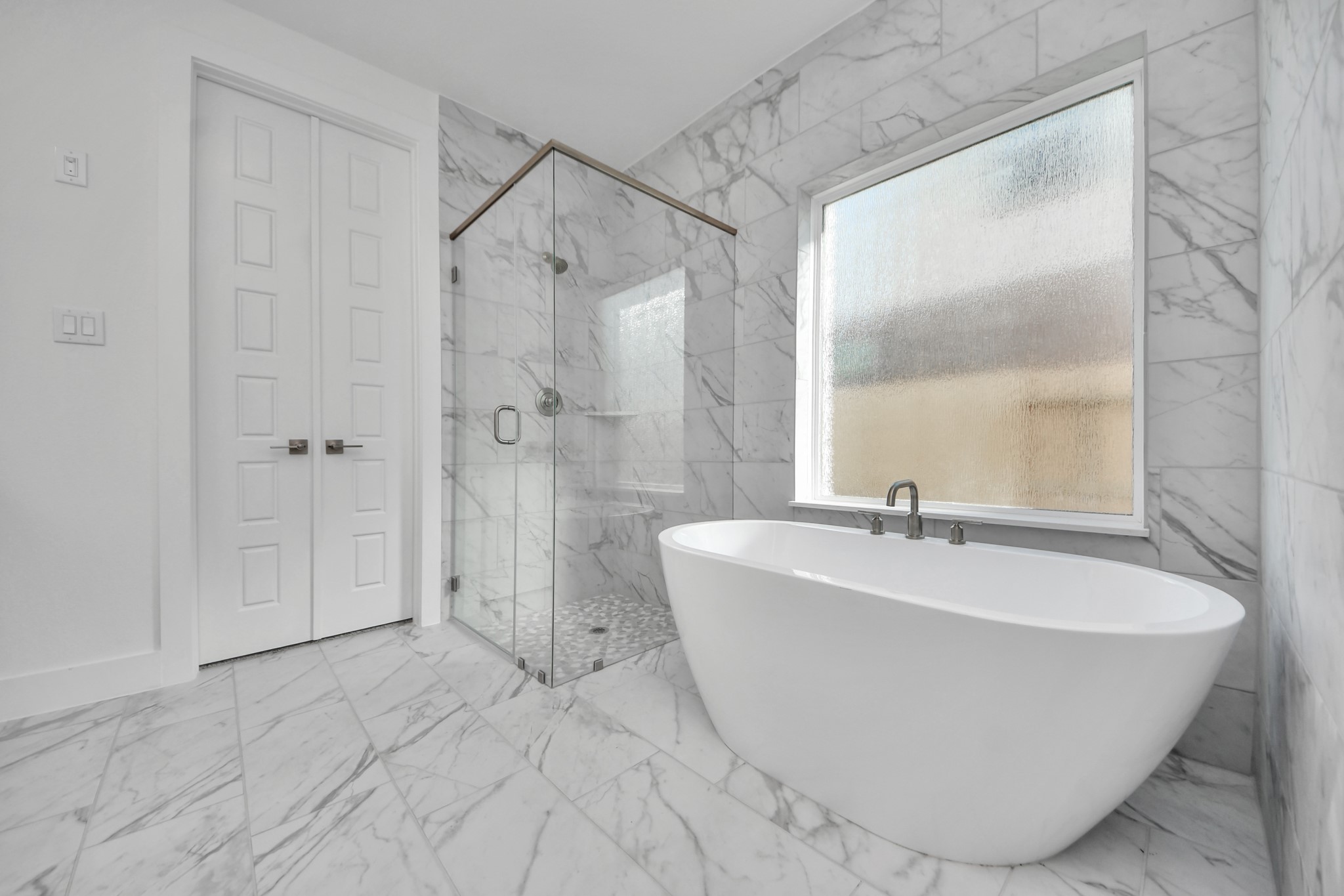 Indulge in a spa-like retreat within the confines of this primary bathroom. Delight in a spacious walk-in shower enveloped in stylish tile surround, unwind in a separate garden tub adorned with custom detailing.