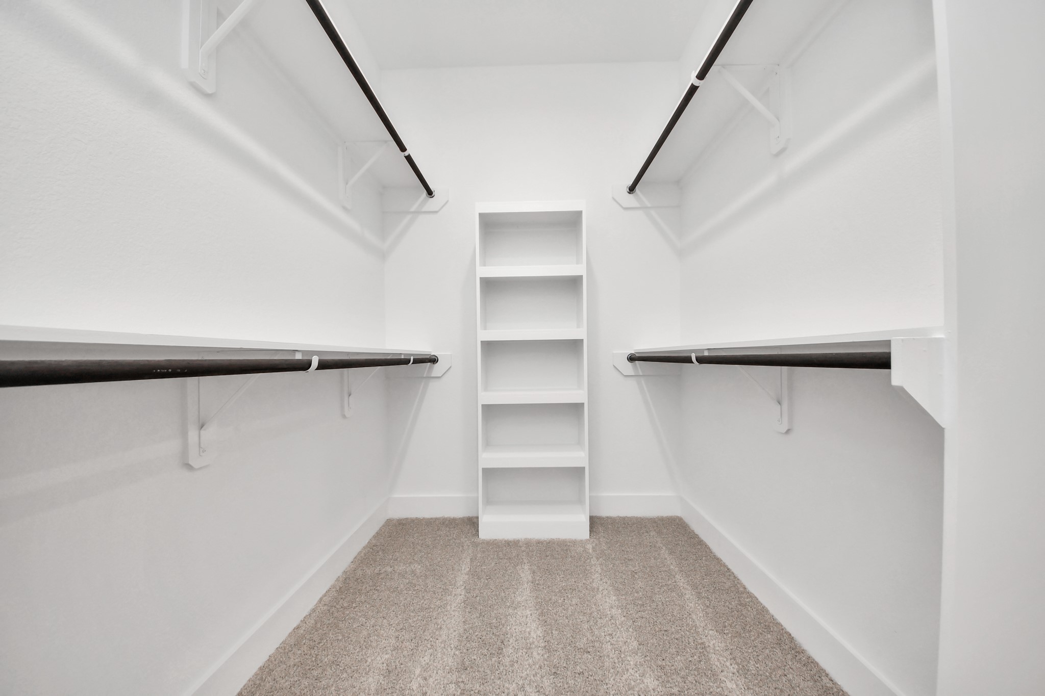 Walk-in closet that epitomizes luxury and practicality. This generously sized space features built-in shelving, offering abundant room for impeccable organization. High ceilings and recessed lighting create a bright and welcoming ambiance.