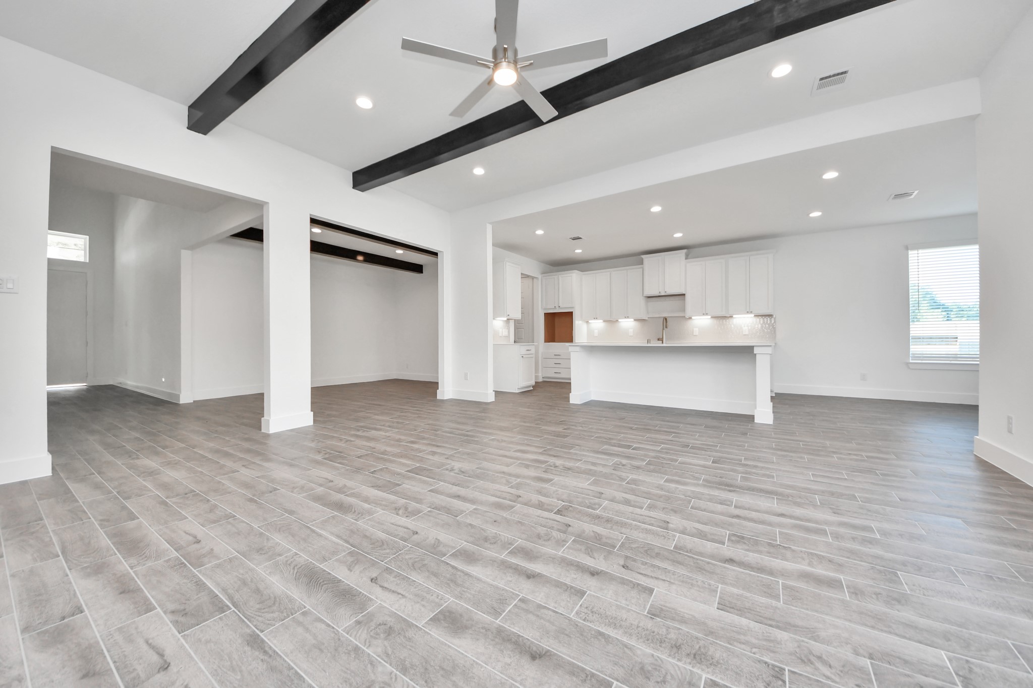Gather the family and guests together in your lovely living room! Featuring soaring high ceilings, recessed lighting, ceiling fan, custom paint, gorgeous floors, and large windows that provide plenty of natural lighting throughout the day.