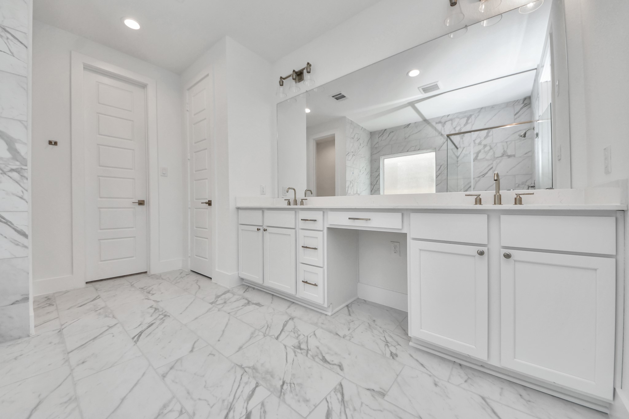 Escape to a spa-like oasis in this primary bathroom. Enjoy a walk-in shower with tile surround, a separate garden tub with custom detailing, and an elegant vanity featuring light countertops, modern hardware, and beautiful vanity lights. Experience luxury and relaxation in every detail.