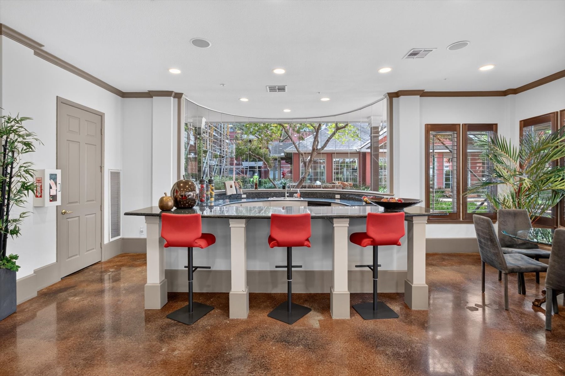 Residents can use the building's stylish and spacious bar area with sleek granite countertops ,barstools, complemented by large windows offering ample natural light and a view of the lush outdoor scenery.