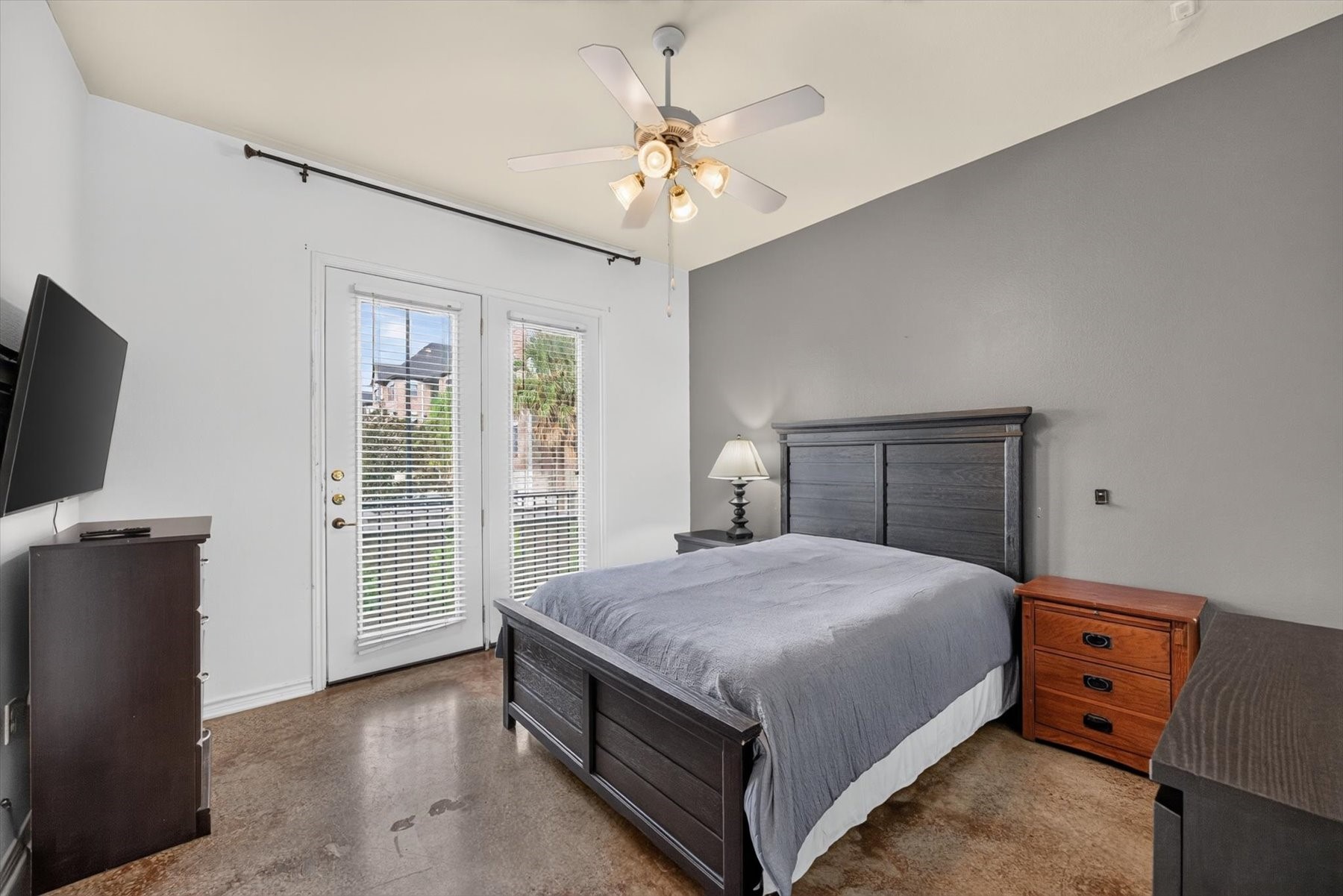 Spacious bedroom with ceiling fan, and ample natural light through French doors.
