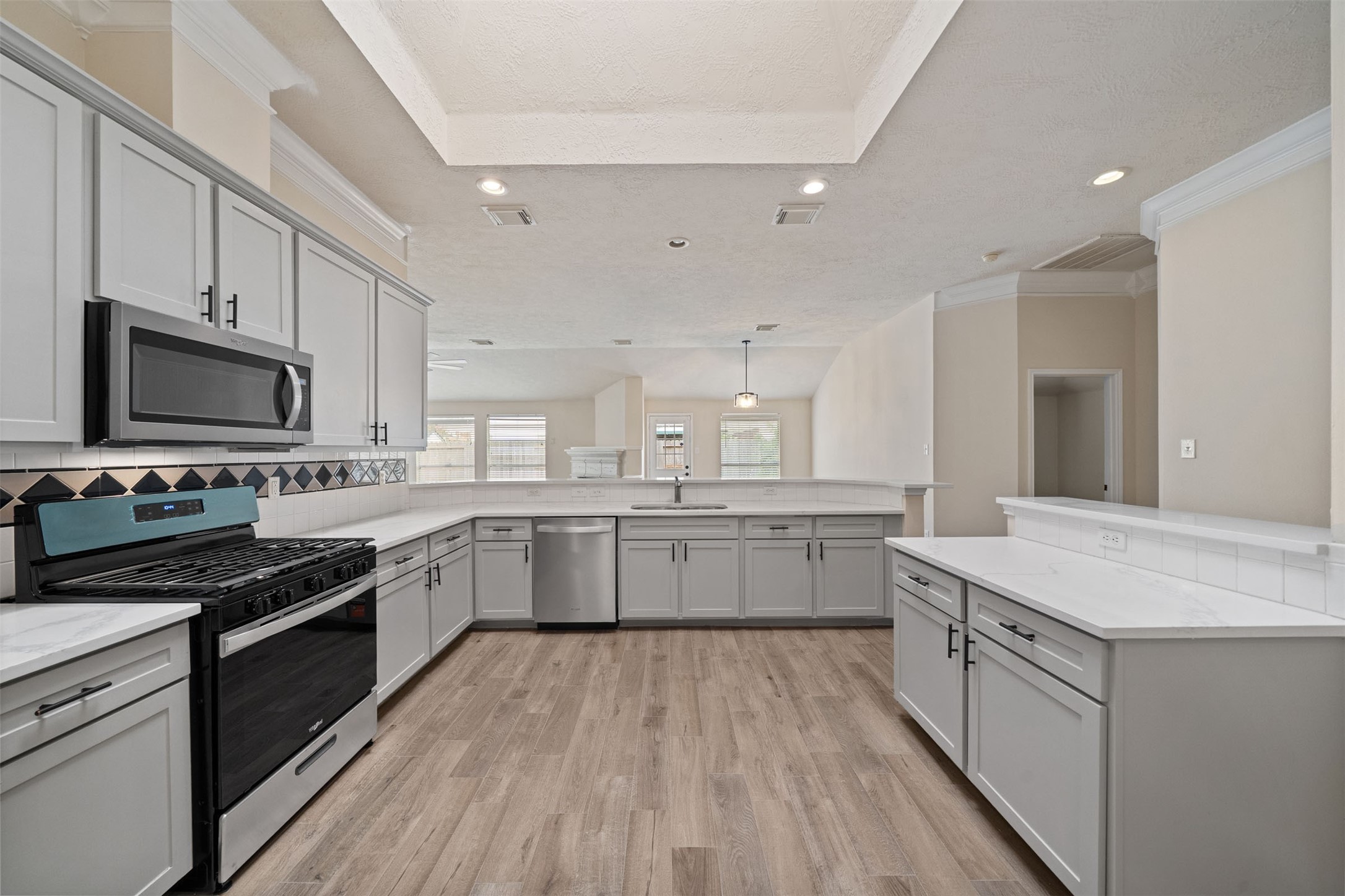 Spacious Renovated kitchen featuring stainless steel appliances, sleek gray cabinetry, new hardware, and Quartz countertops Spacious Renovated kitchen featuring stainless steel appliances, sleek gray cabinetry, new hardware, and Quartz countertops