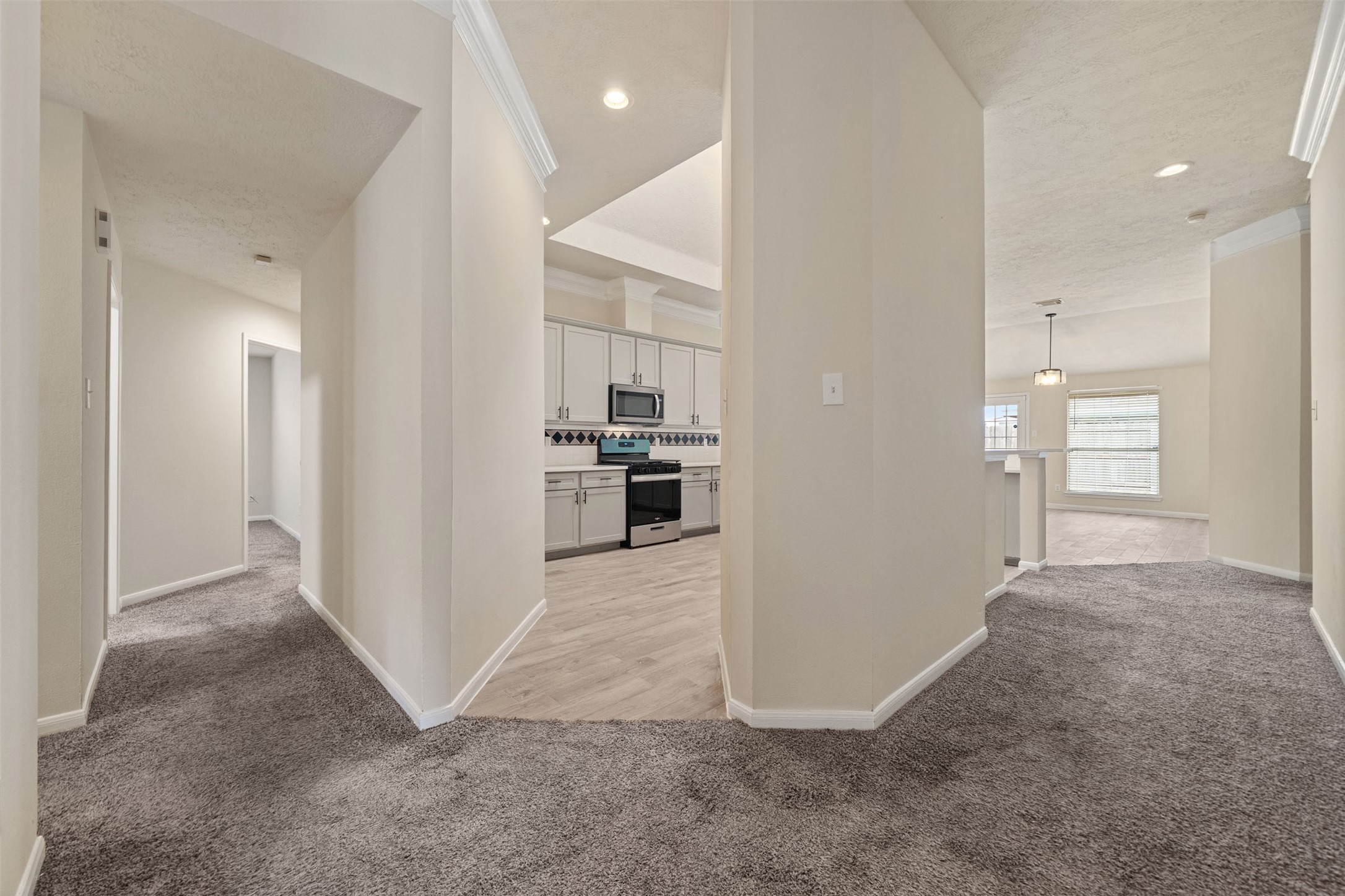 Bright and inviting hallway leads to a modern kitchen and seamlessly connecting to the bright breakfast area and den