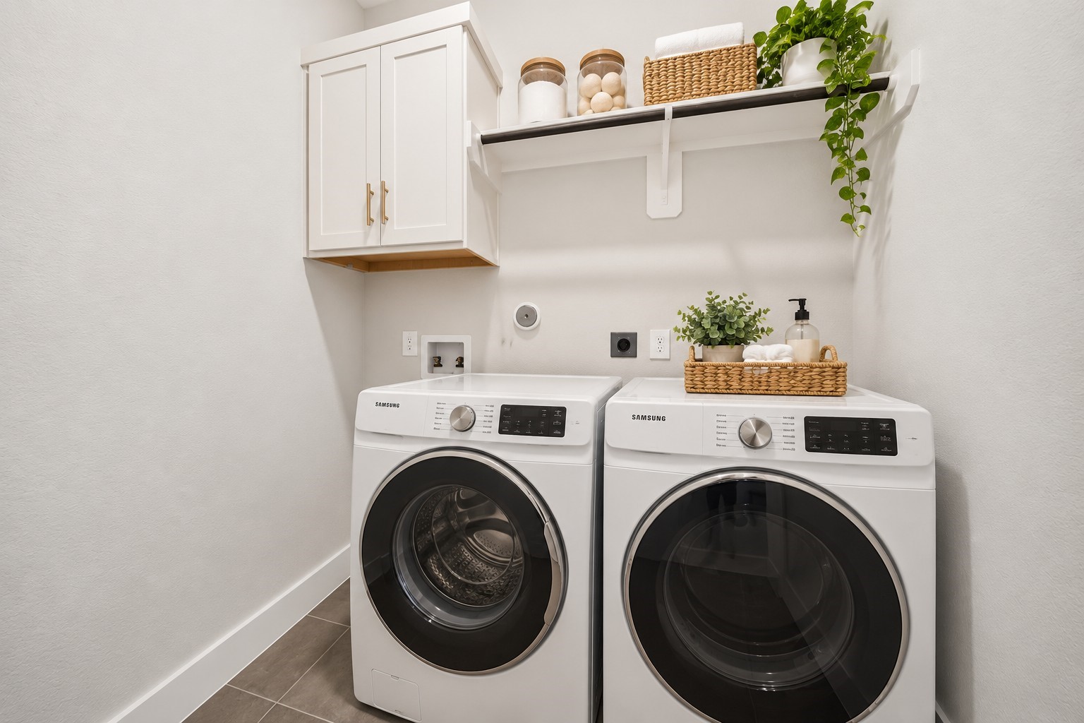 Laundry Room: Dedicated laundry area featuring upper cabinetry, open shelving, and convenient side-by-side laundry connections for practical everyday organization.