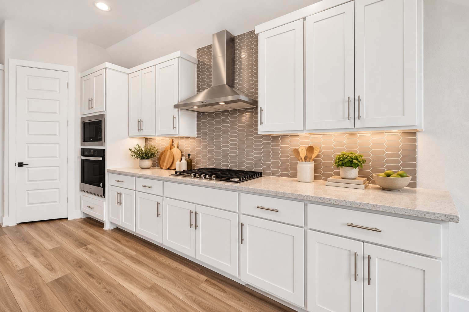 Kitchen  Designer Details: Beautifully appointed kitchen featuring a gas cooktop, stainless steel vent hood, decorative tile backsplash, illuminated cabinetry, and generous countertop space that combines elegance with everyday functionality.