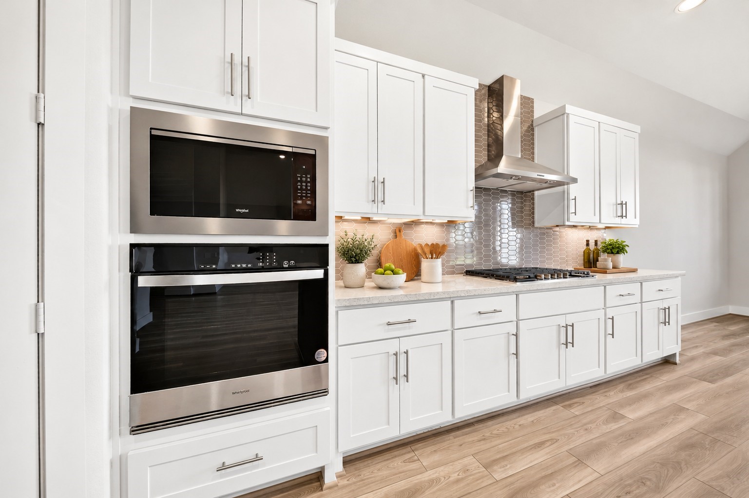 Gourmet Kitchen: Sophisticated kitchen showcasing built-in stainless steel appliances, elegant white cabinetry, under-cabinet lighting, decorative tile backsplash, and sleek countertops.