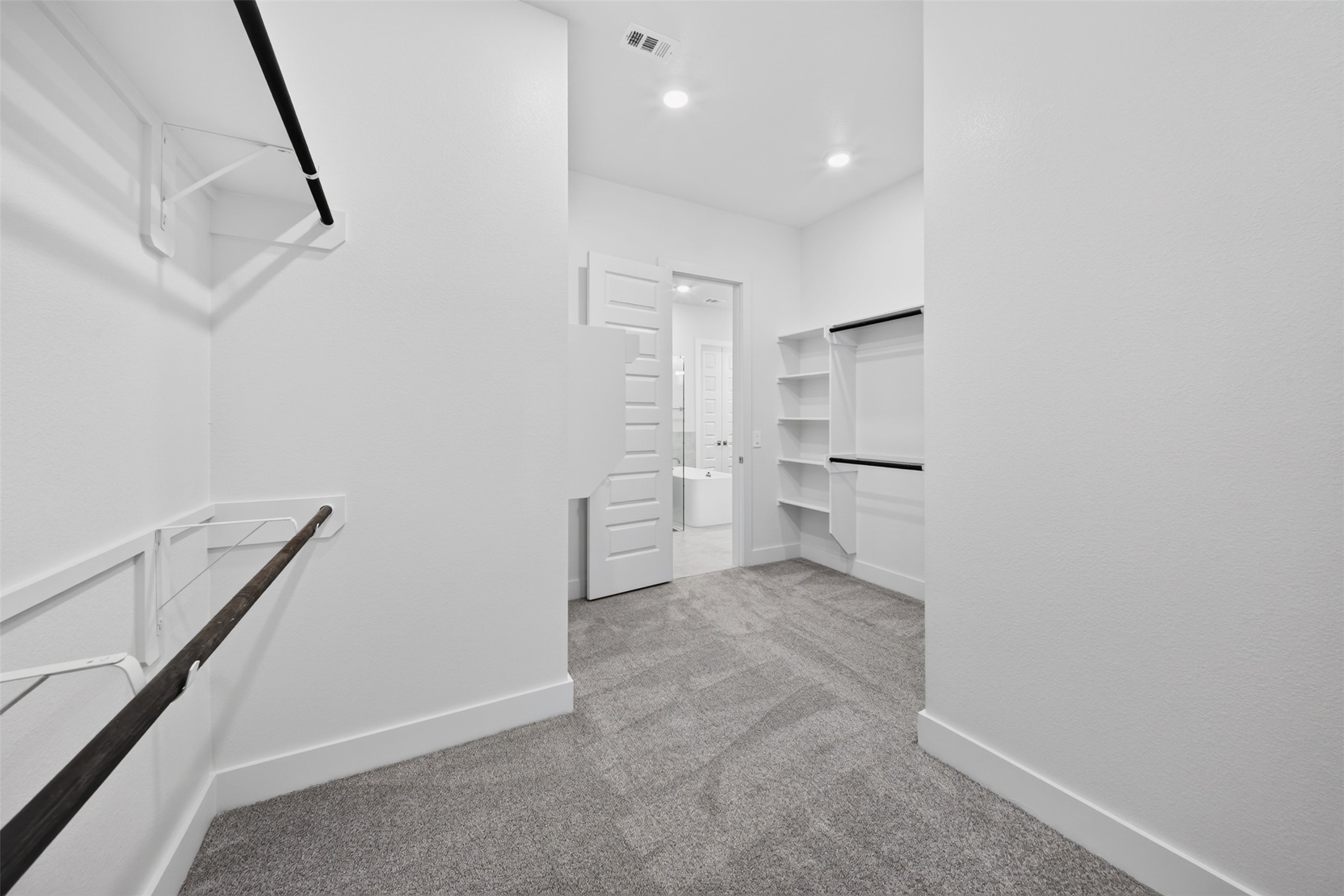 Primary Walk-In Closet: Generously sized primary closet featuring multiple hanging areas, shelving, and an expansive layout for everyday organization.