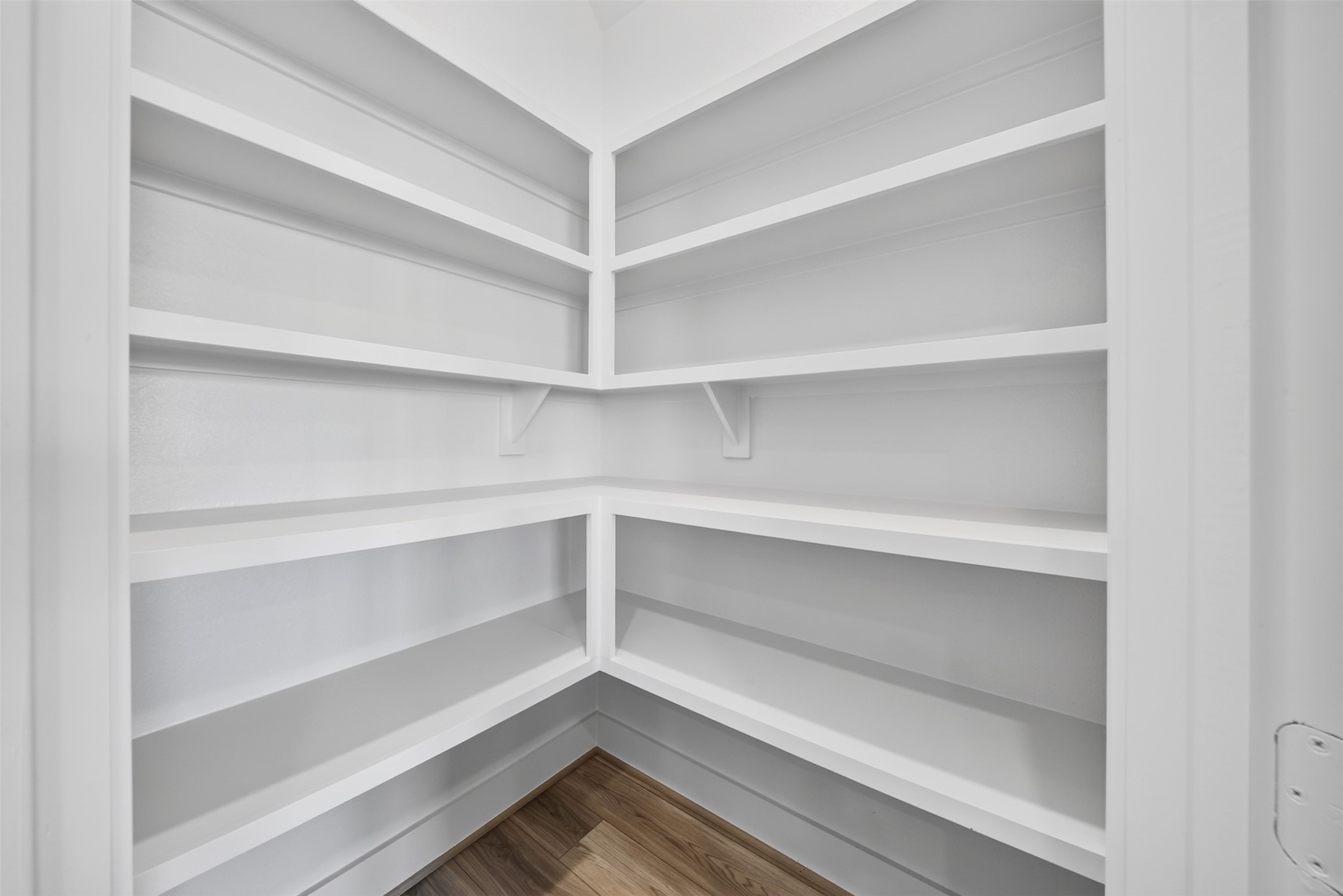 Walk-In Pantry: Generously sized pantry featuring wraparound built-in shelving, providing abundant organized storage for kitchen essentials, cookware, and everyday necessities.