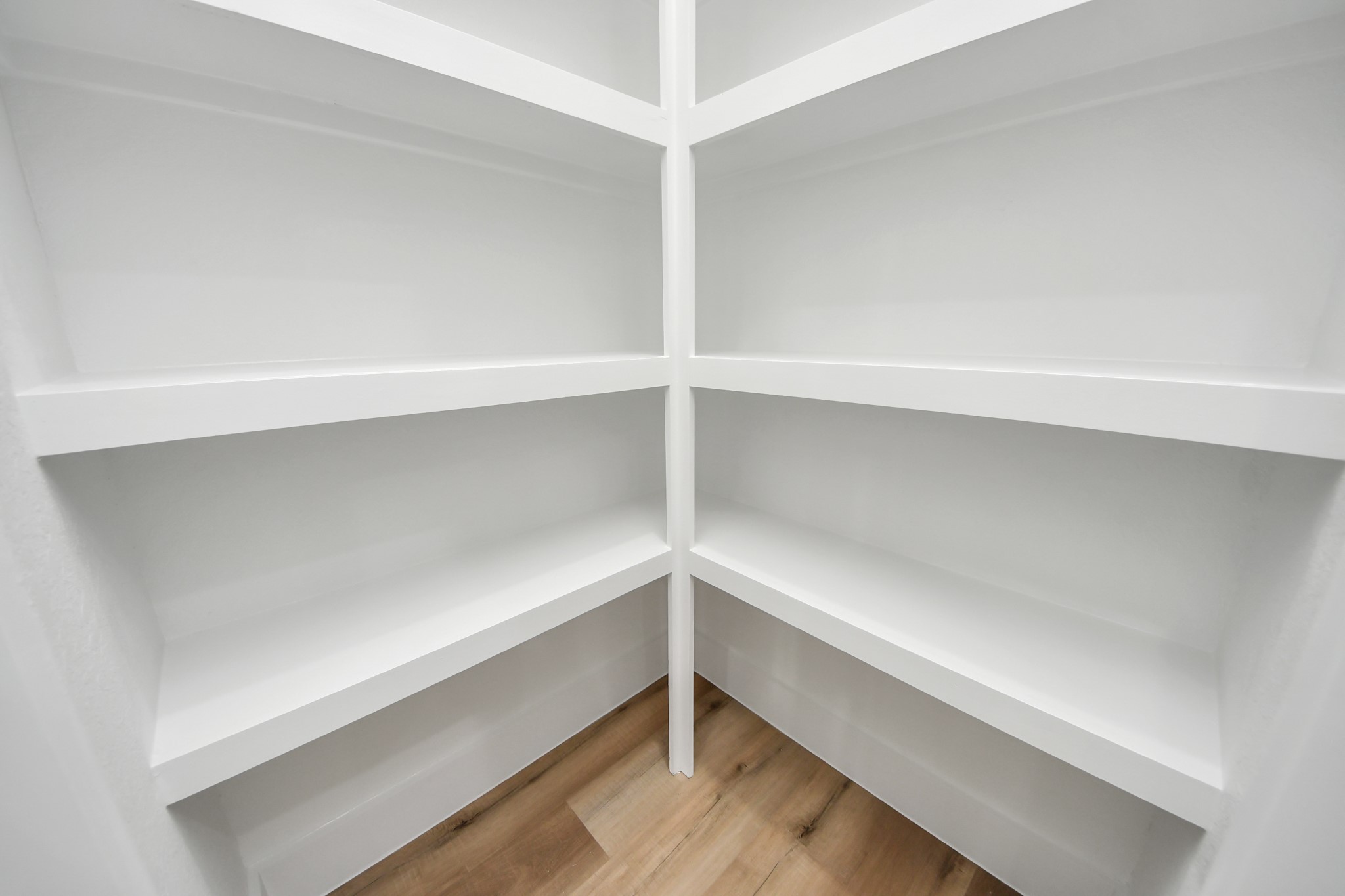 Spacious and bright corner shelving offers ample storage with sleek white finishes, perfect for organizing your essentials.