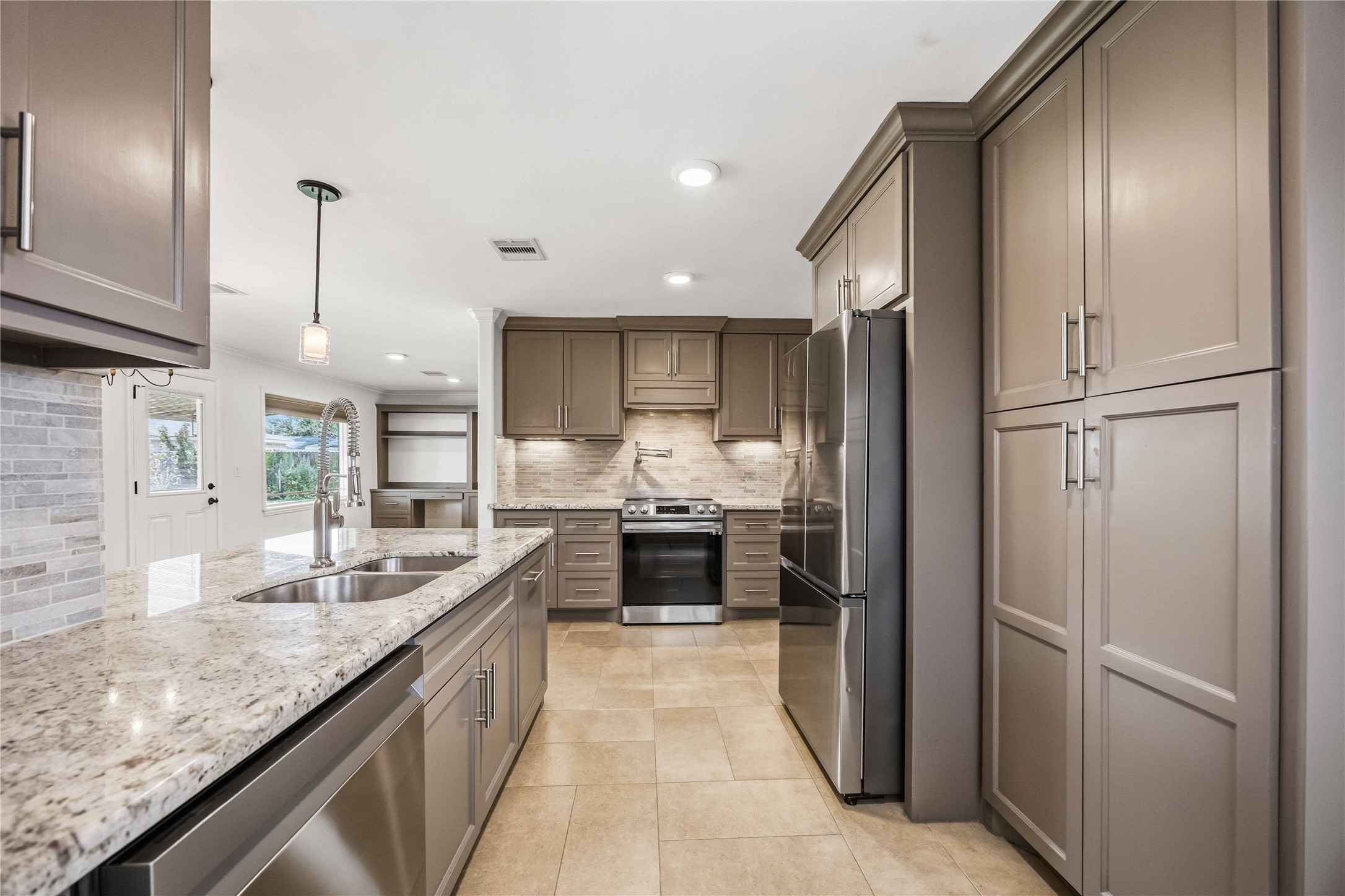 Beautiflly remodeled kitchen! Plentiful cabinet space, w/ modern pulls, high-end stainless steel appliances, appealing backsplash & timeless granite countertops!