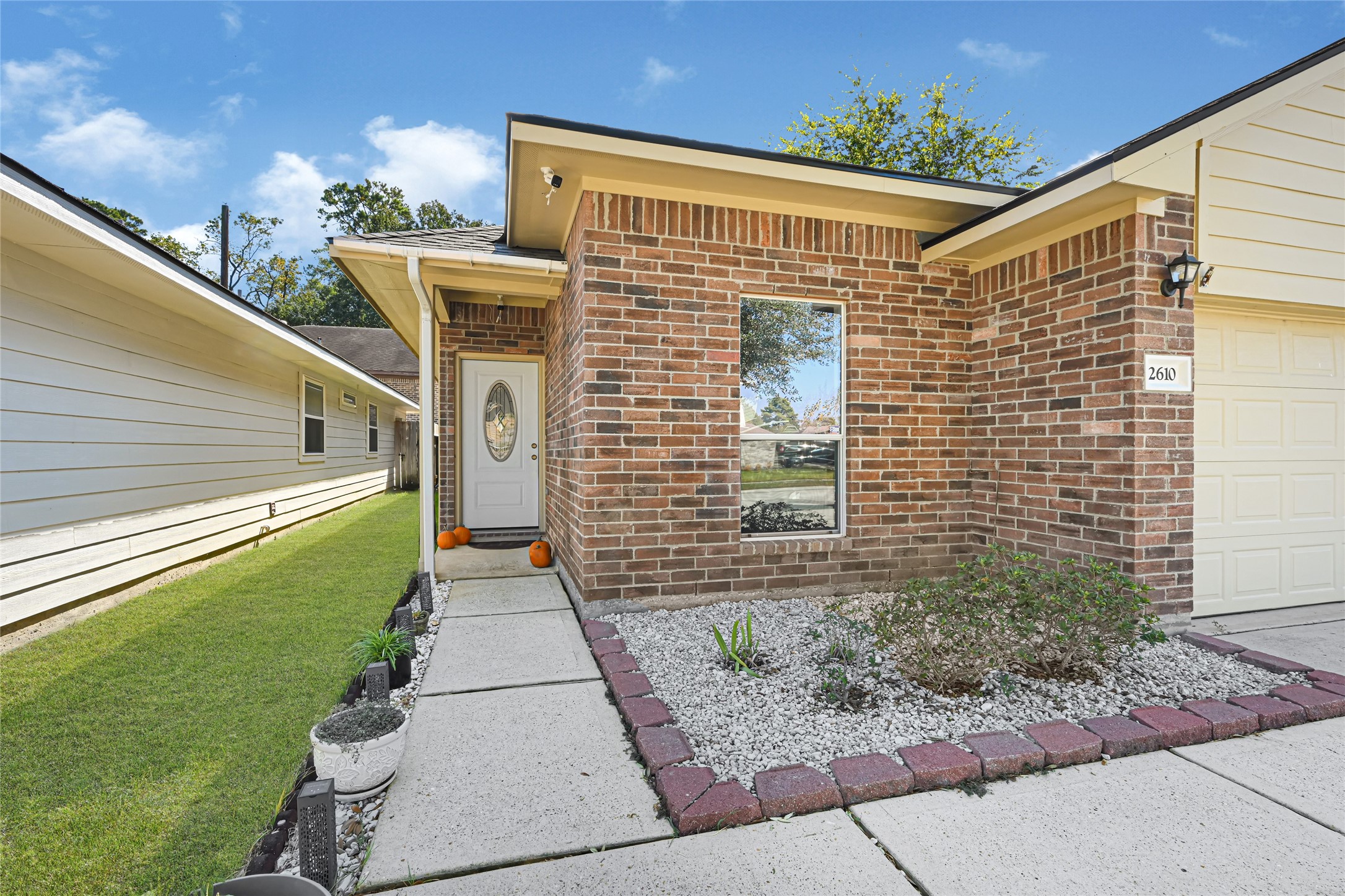 Charming brick exterior with a welcoming front entry, featuring a decorative door and a tidy landscaped path. Charming brick exterior with a welcoming front entry, featuring a decorative door and a tidy landscaped path.