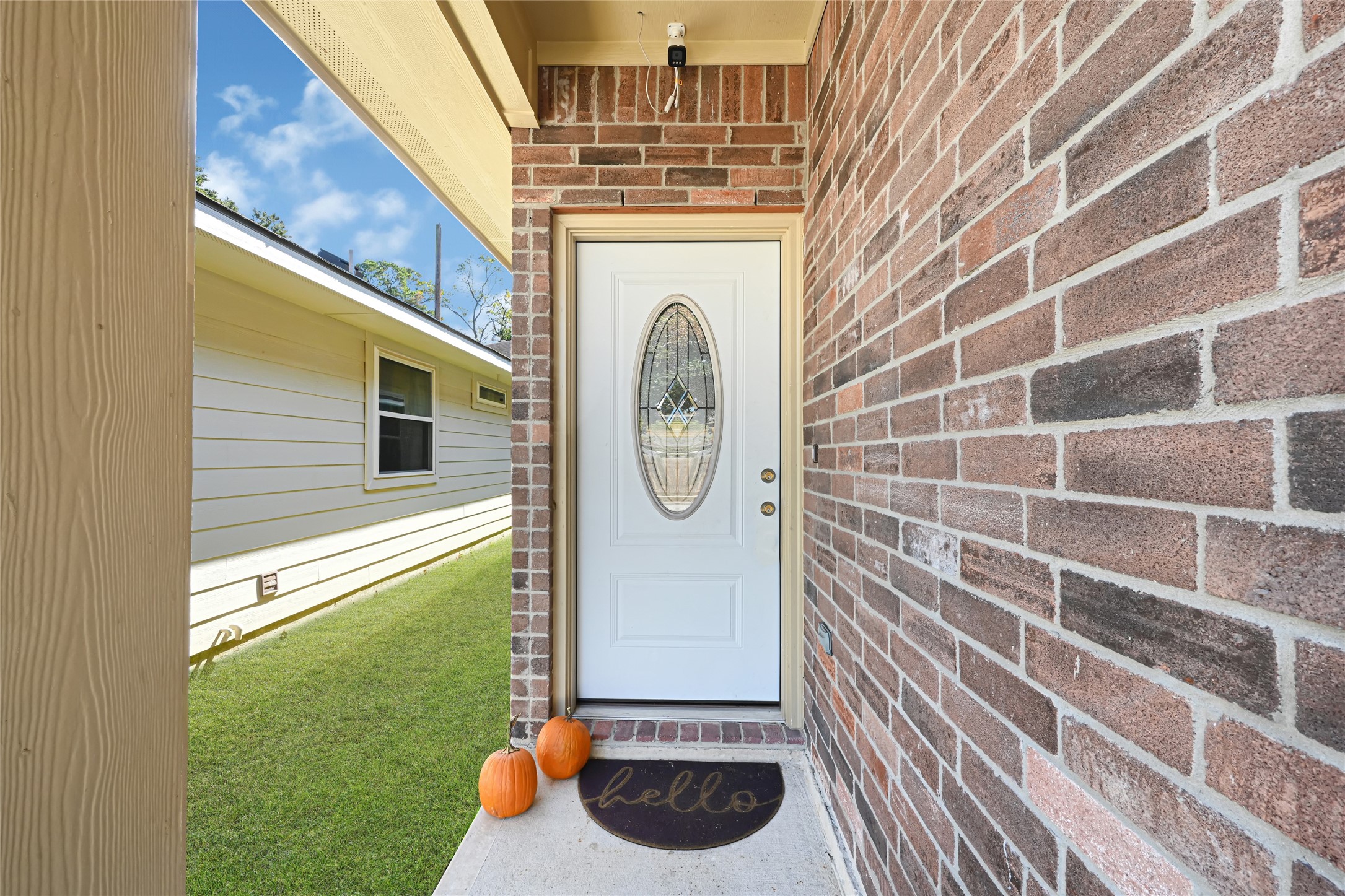 Charming front entrance with a stylish brick facade and a welcoming door featuring an elegant oval glass insert. Charming front entrance with a stylish brick facade and a welcoming door featuring an elegant oval glass insert.