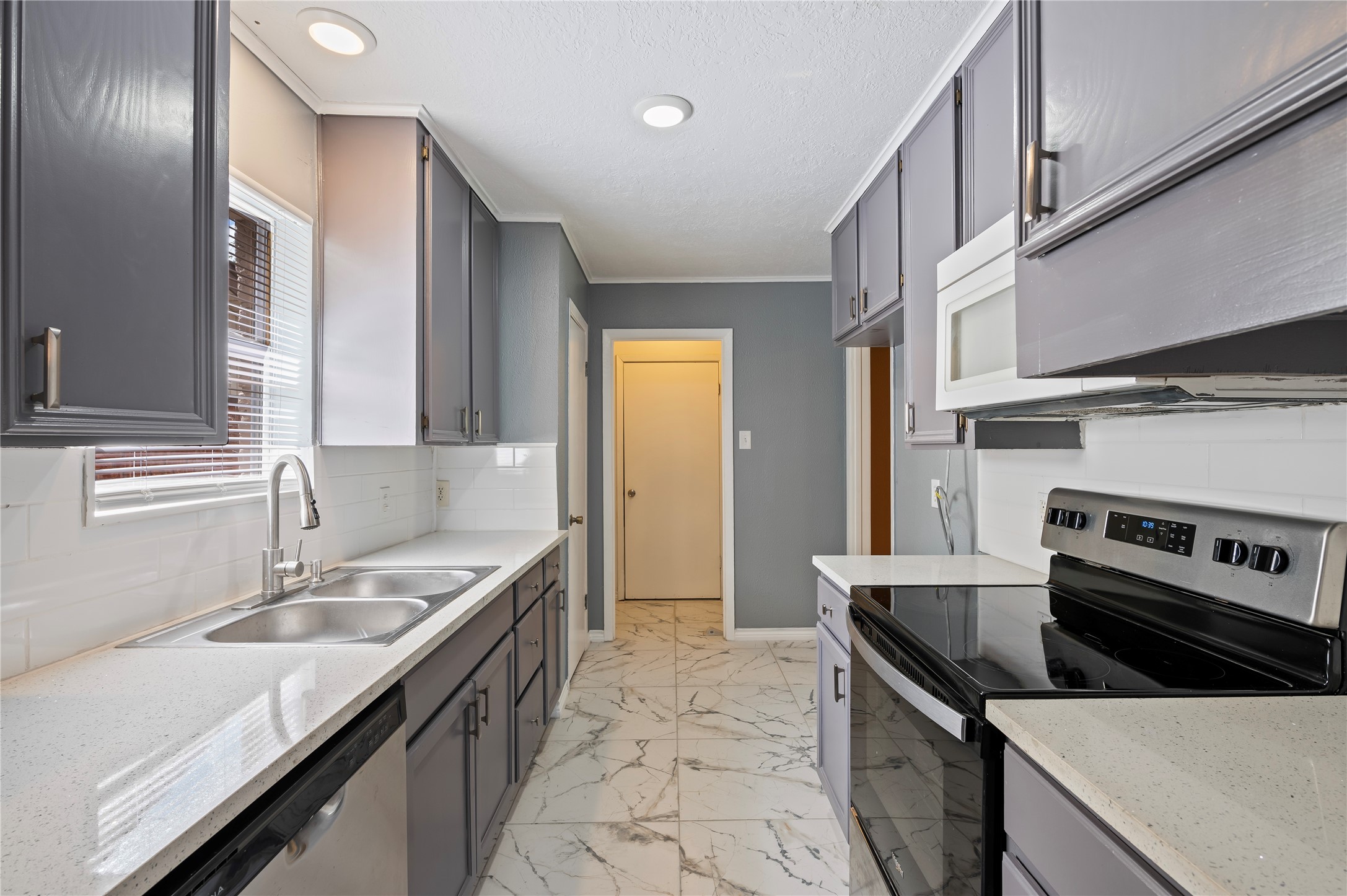 Quartz countertops. Laundry room at the end of of the kitchen