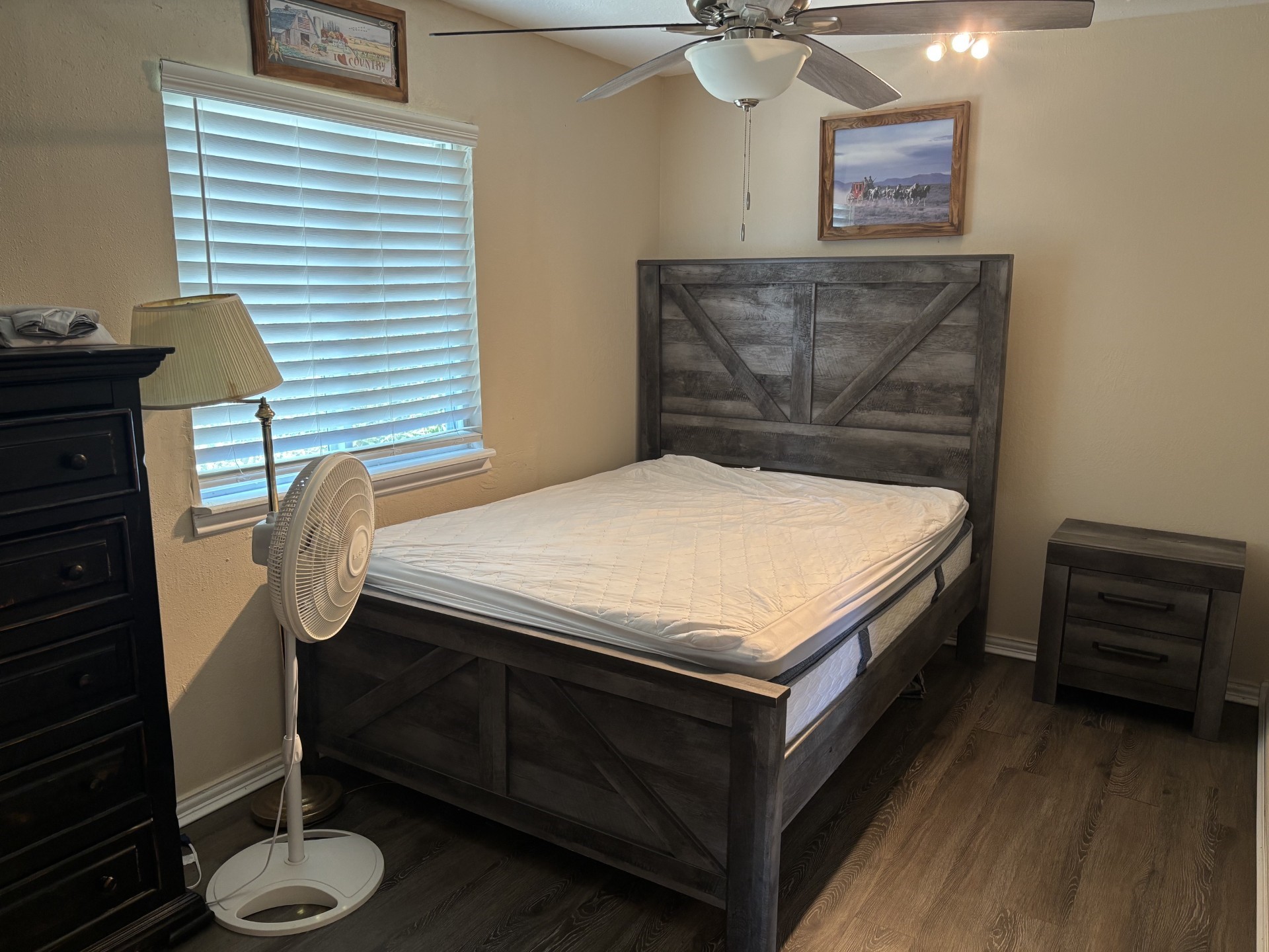 Cozy bedroom with a sleek nightstand and wood like flooring. Cozy bedroom with a sleek nightstand and wood like flooring.