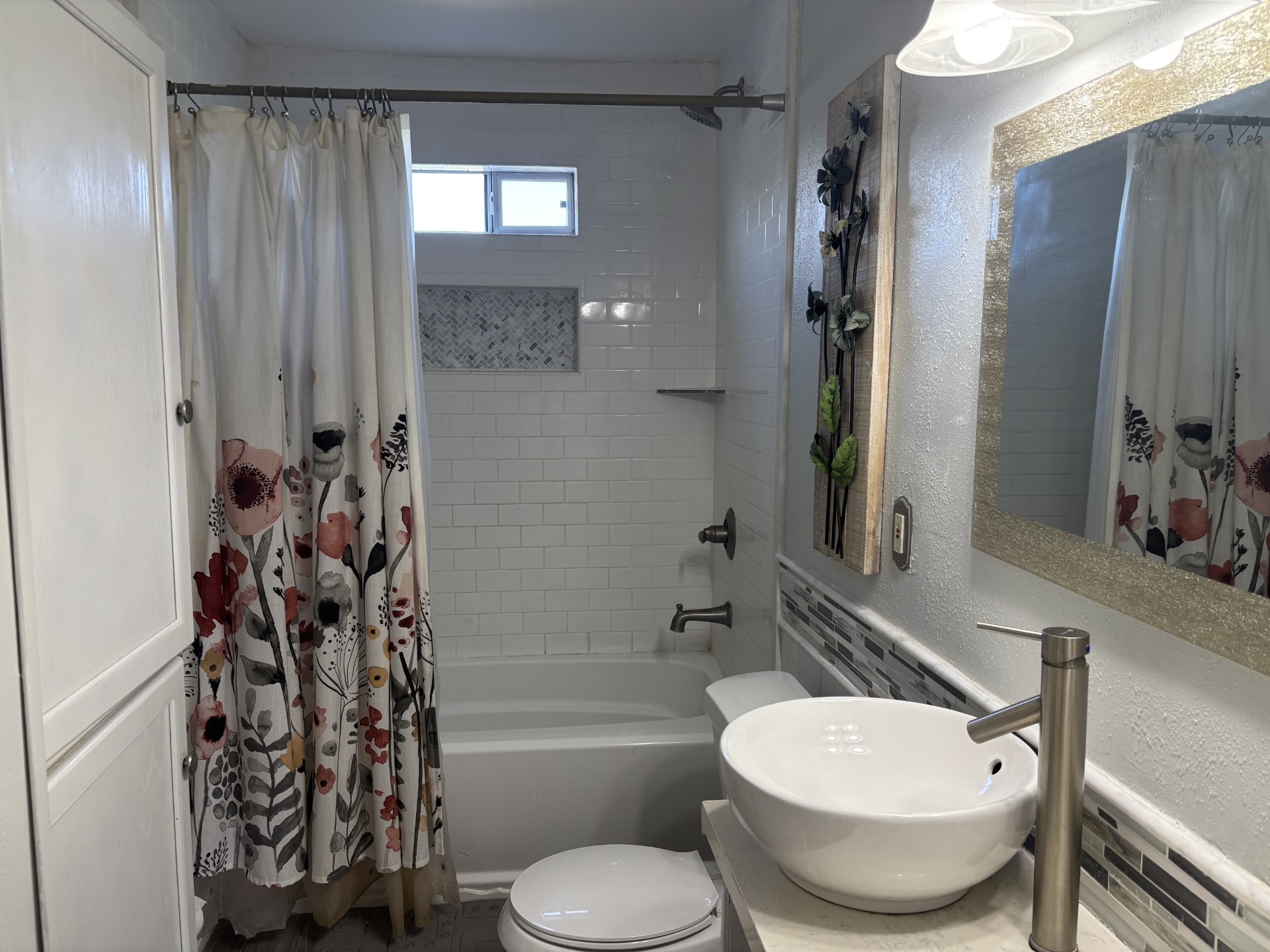 stylish bathroom, with subway tile, tub/shower combo, and wood like flooring