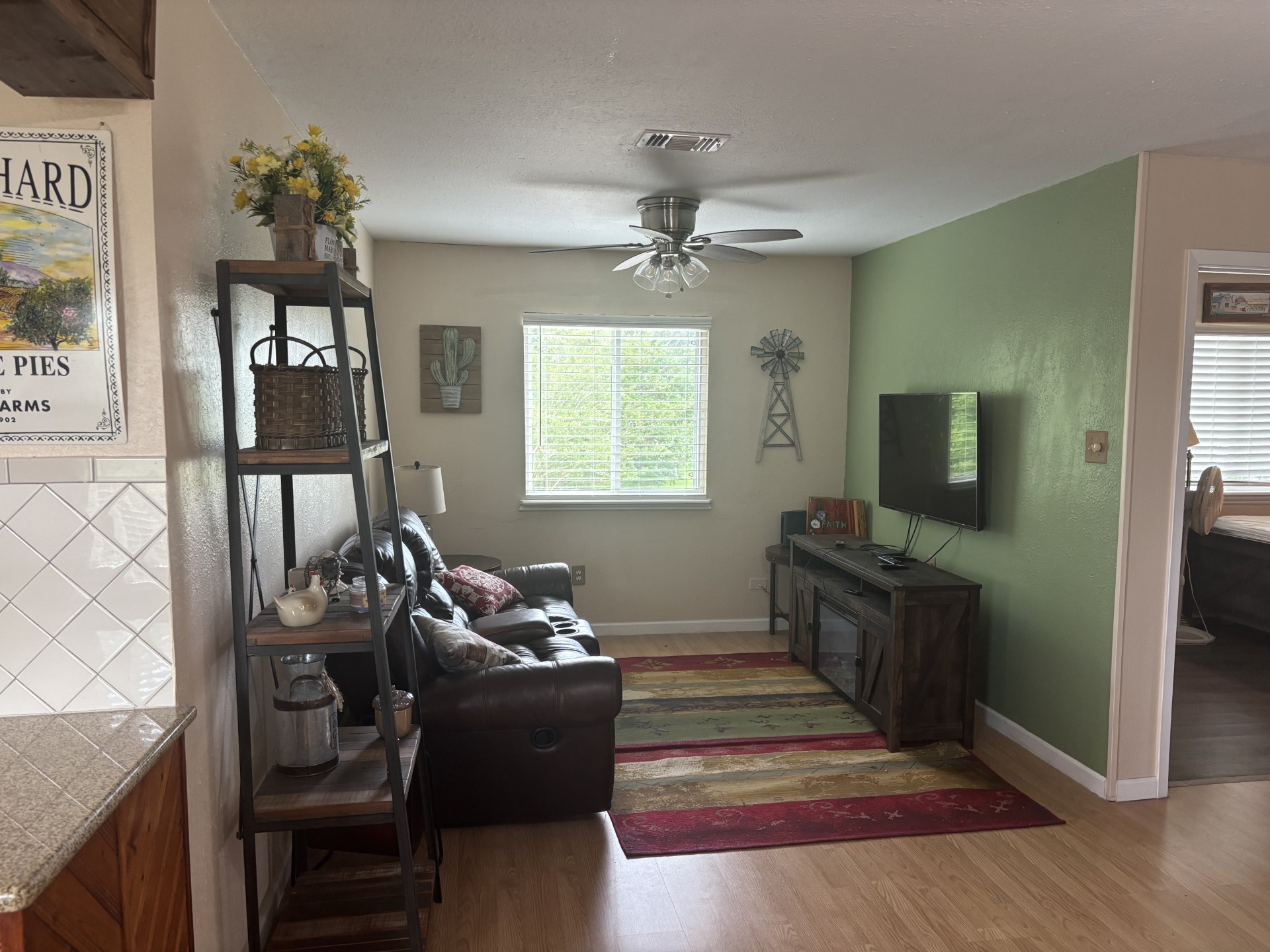 Inviting living area with a wall-mounted TV, plush seating, and stylish accent rugs. Inviting living area with a wall-mounted TV, plush seating, and stylish accent rugs.
