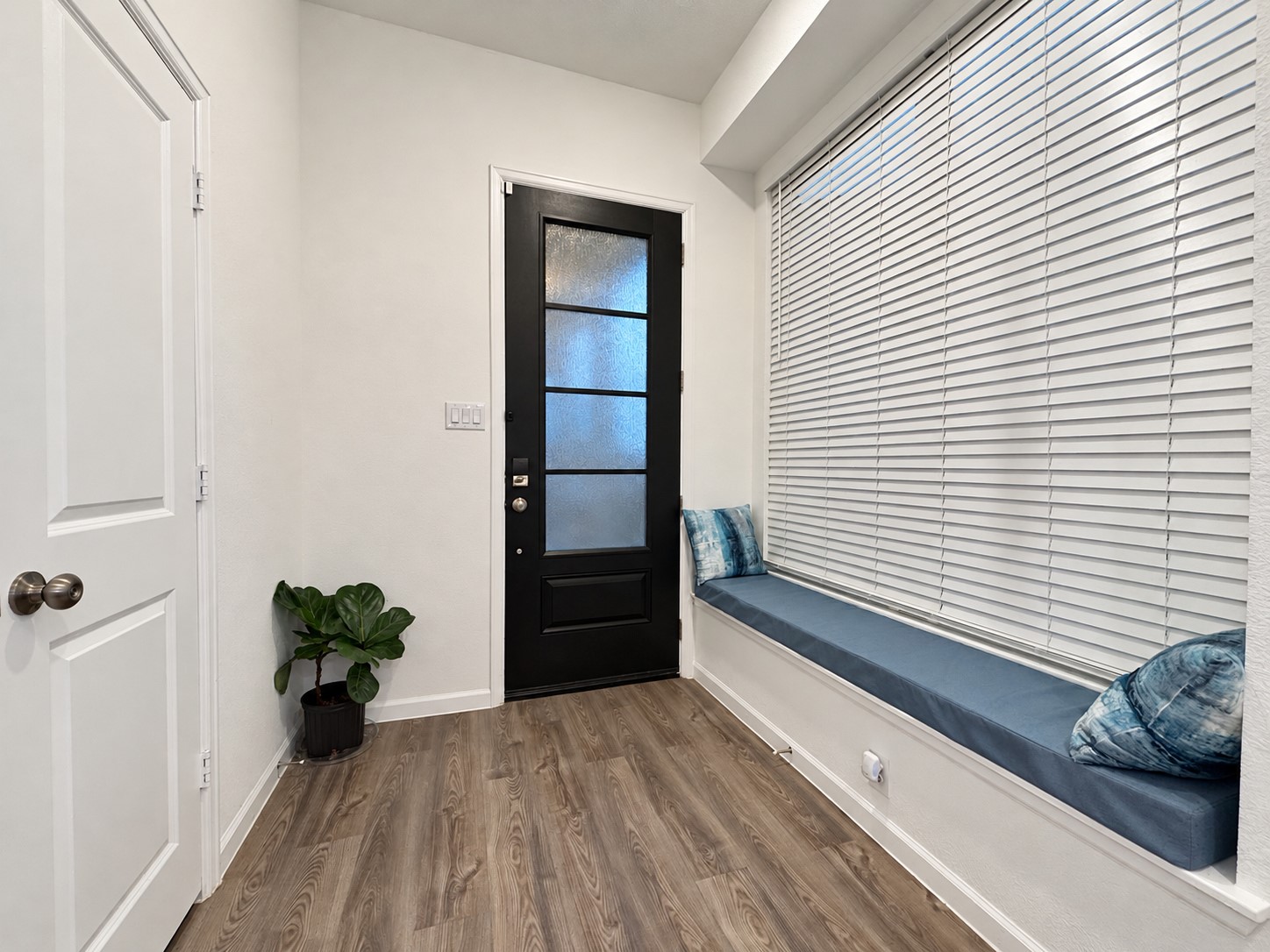 6. Welcoming entry with a distinctive glass-paneled door and built-in window seat.