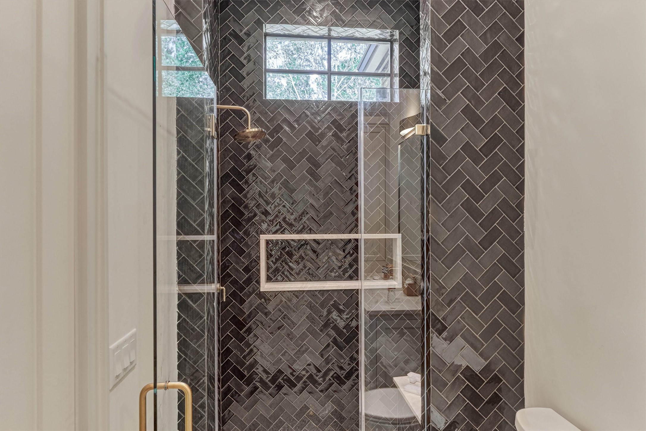 Beautifully appointed ensuite bath showcasing it's beautiful tilework, elegant glass enclosed shower and refined finishes throughout.