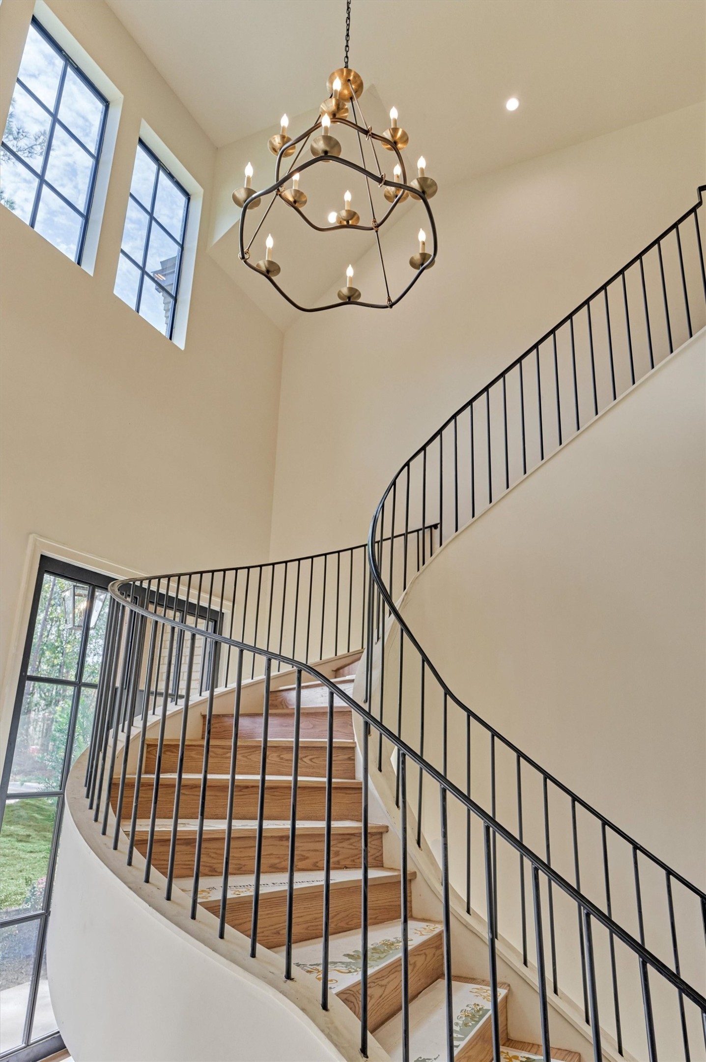 A captivating perspective of the grand entry, where the sculptural floating staircase creates an unforgettable architectural statement and sets the tone for the elegance throughout.