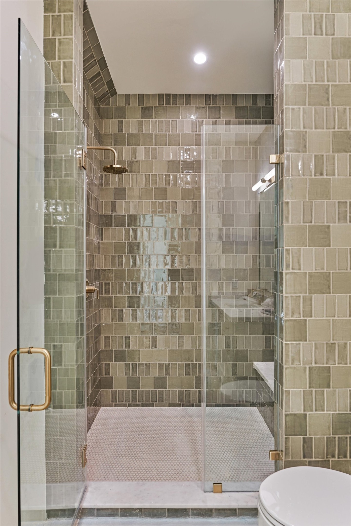 Another ensuite bath showcasing a walk in shower with a generous built in bench and sophisticated tile selection.