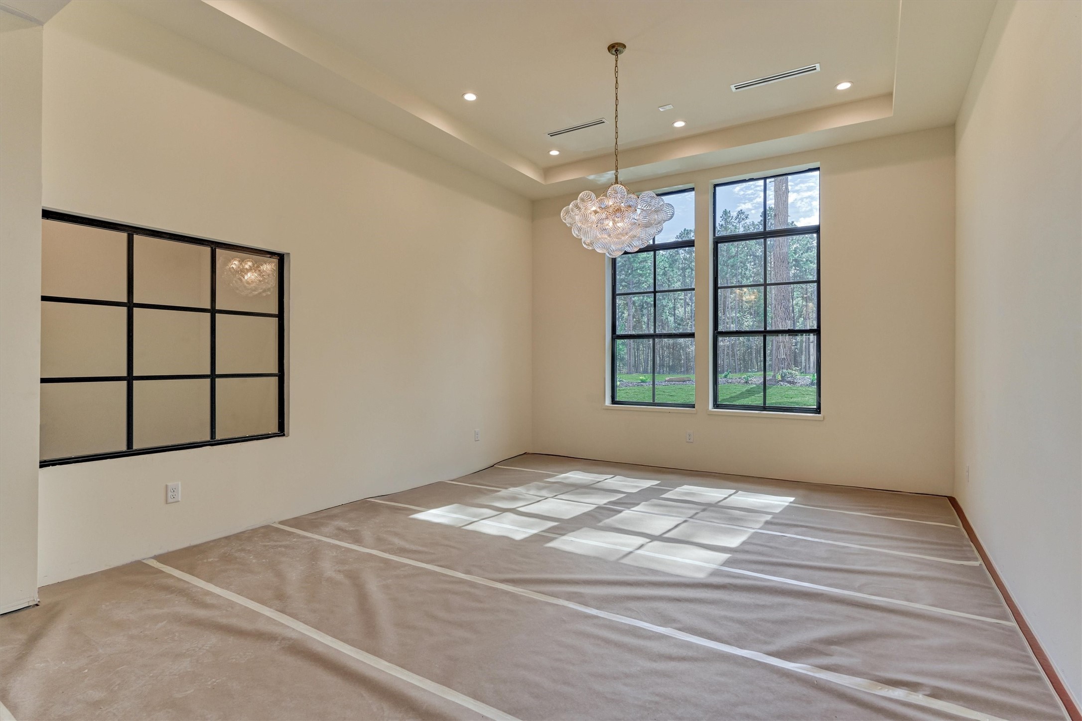 An elegant dining space complemented by a stunning glass enclosed private wine cellar, thoughtfully integrated beneath the staircase.