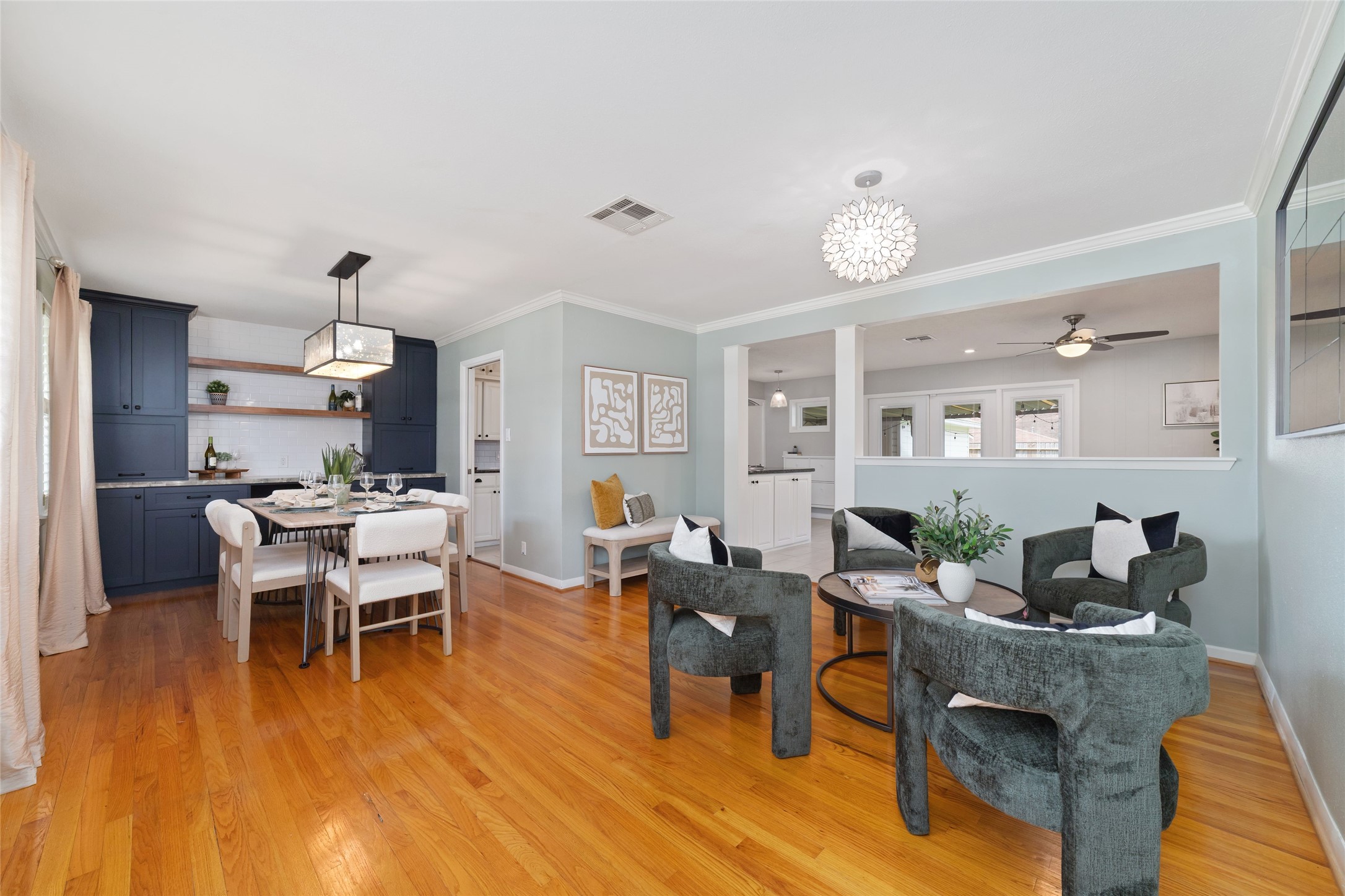 Elegant open-concept dining and den area featuring hardwood floors and built in cabinetry.
