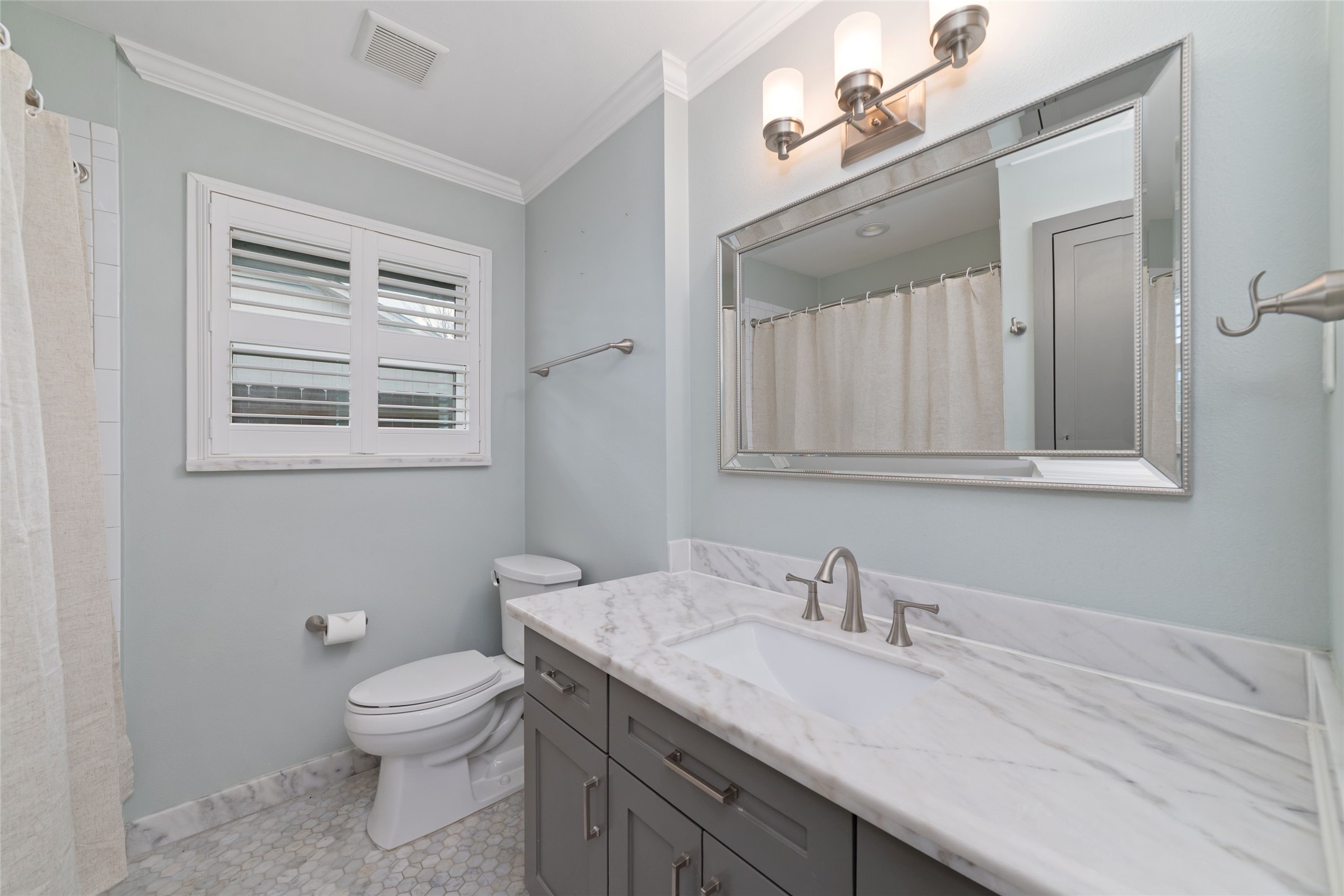 The remodeled secondary bath features a tub/shower combination and built-in cabinetry for ample storage.