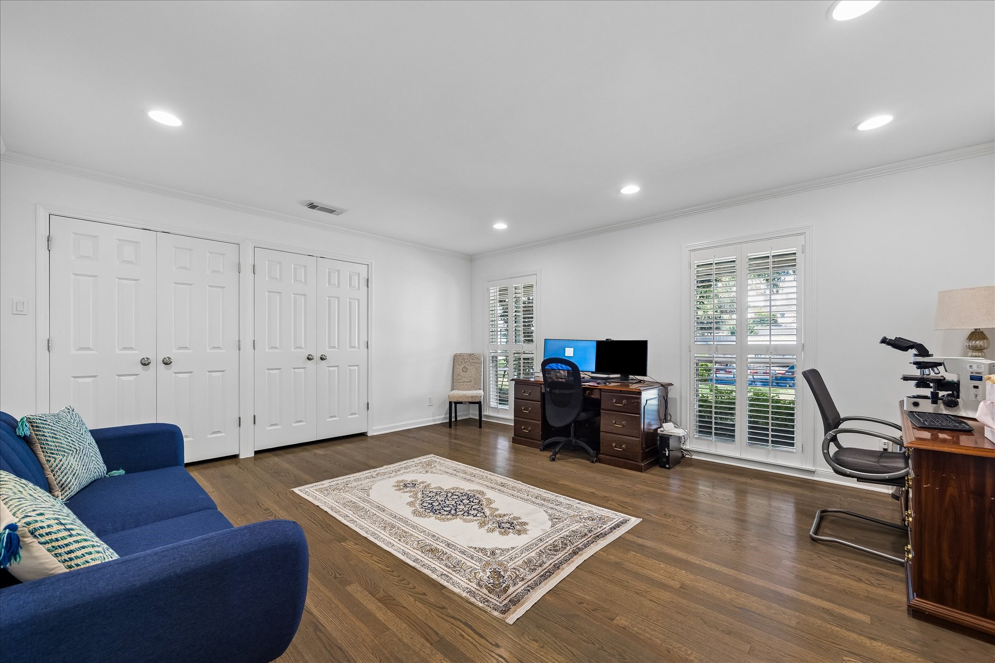 Spacious secondary bedroom currently utilized as a home office & sitting area offers wonderful versatility for a variety of uses. Features beautiful hardwood floors, crown molding, recessed lighting, two closets & large windows w/plantation shutters that bring in natural light. Expansive layout easily accommodates bedroom furnishings, a home office or additional living space.