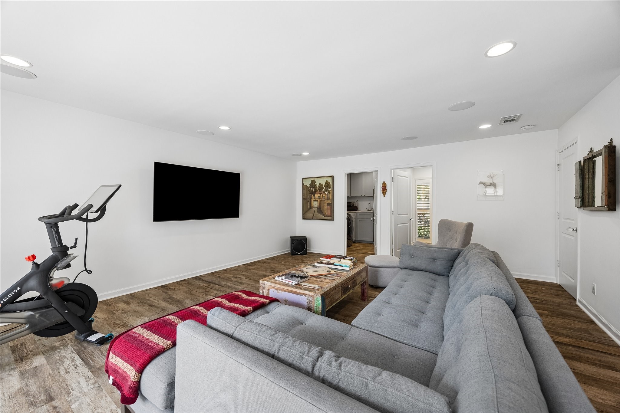 Den provides a great room for relaxing, entertaining or enjoying movie nights. Features include recessed lighting, wood flooring & convenient access to the utility room, nearby half bath & additional living spaces.