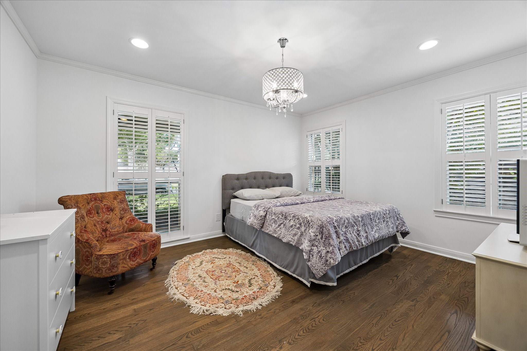 Bright & spacious secondary bedroom features beautiful hardwood floors, crown molding, recessed lighting & decorative chandelier. Multiple windows w/plantation shutters provide wonderful natural light.
