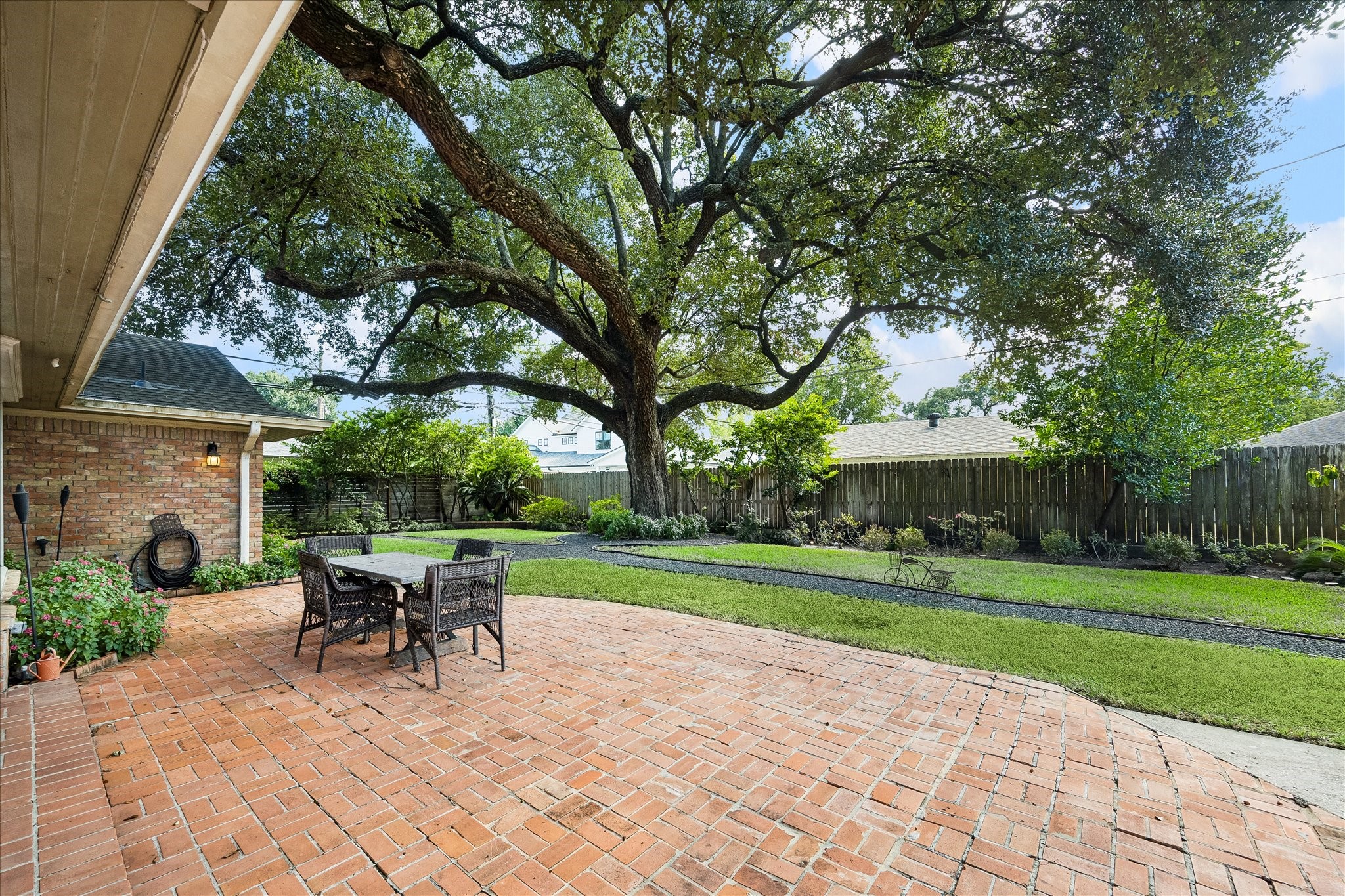 Spacious brick patio creates an inviting outdoor entertaining area w/room for dining & seating. Overlooking the beautifully landscaped backyard, a magnificent mature oak tree provides an impressive canopy of shade.