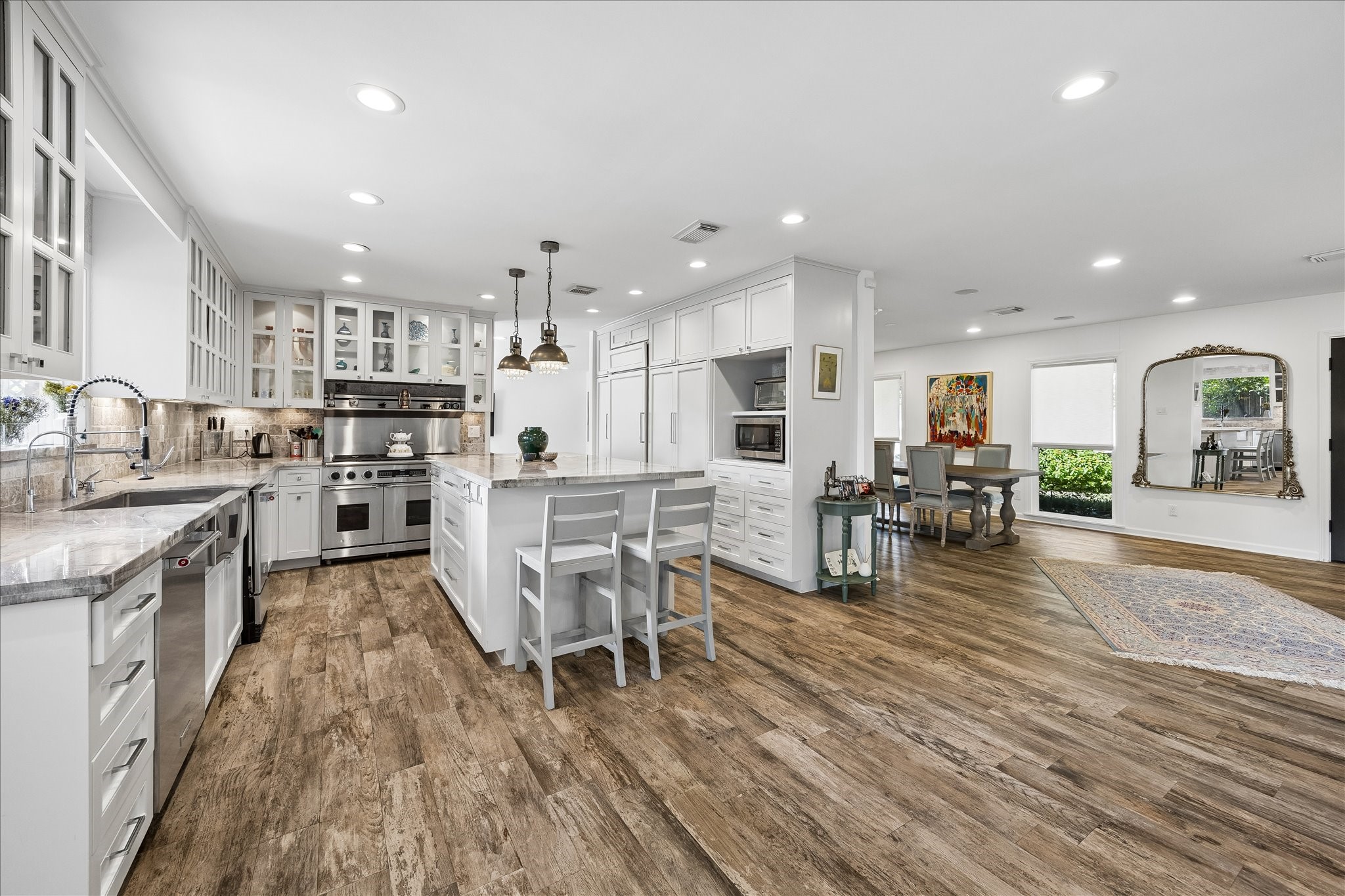 Spacious open-concept kitchen & dining area features beautiful wood-look flooring, extensive custom cabinetry, stainless steel appliances & a large island w/breakfast bar seating. The adjoining dining area offers wonderful natural light & flexibility for entertaining.