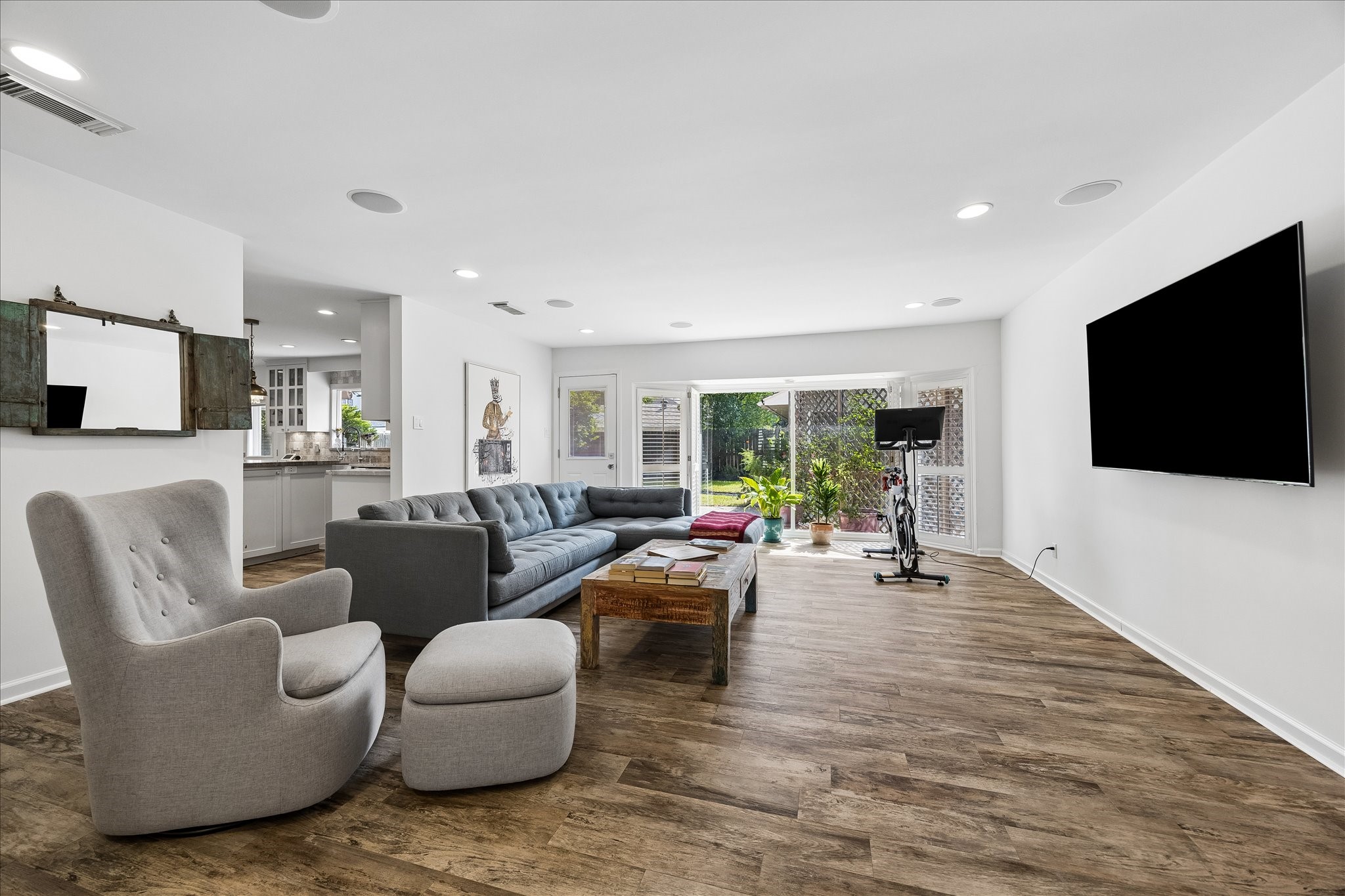Spacious den offers a wonderful secondary living area w/wood-look flooring, recessed lighting, built-in ceiling speakers & a wall-mounted TV. Large windows overlook the backyard, filling the space w/natural light.