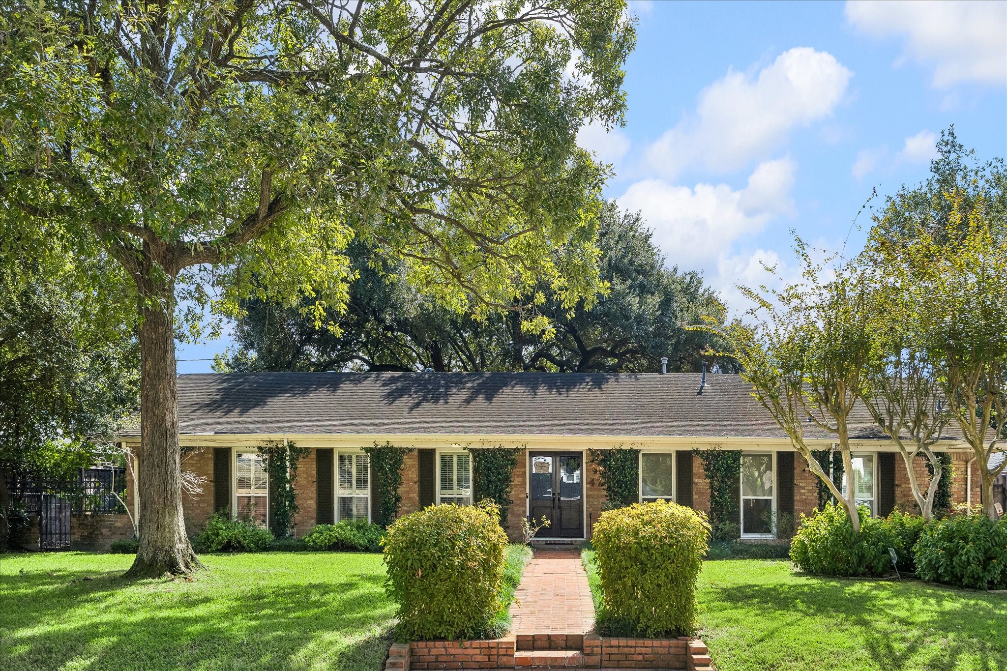 This home showcases a beautiful brick exterior, mature shade trees, manicured landscaping & brick walkway leading to the welcoming double-door entry.
