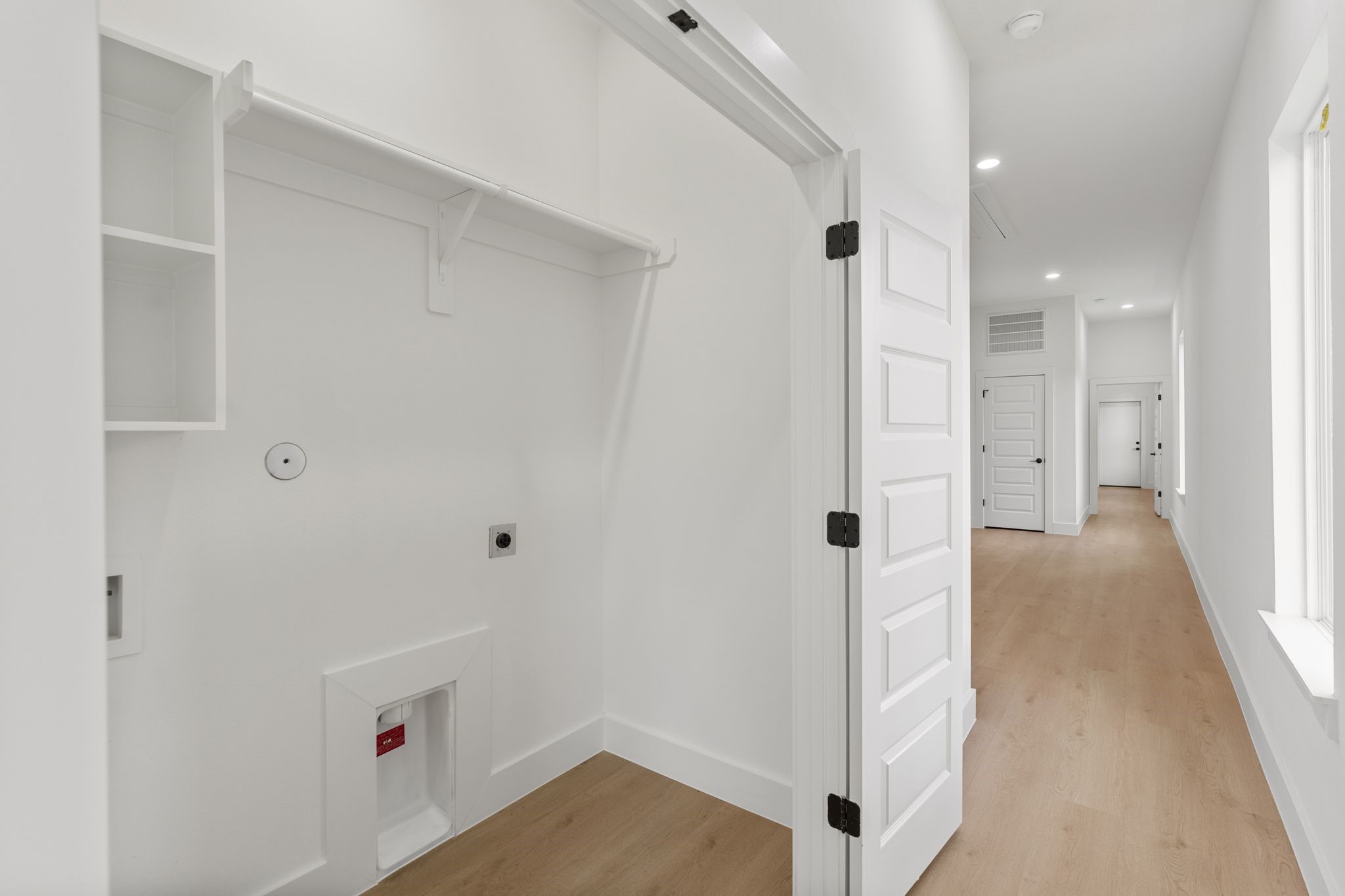 Bright and airy storage space featuring built-in shelves and a large window for natural light.