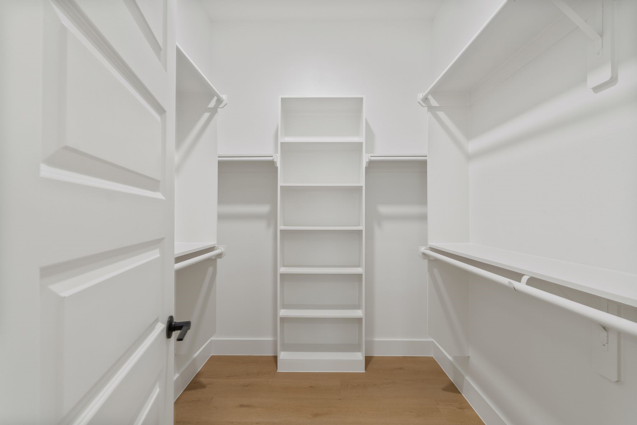 Spacious walk-in closet featuring ample shelving and hanging space, perfect for organized storage and easy access to your wardrobe essentials.