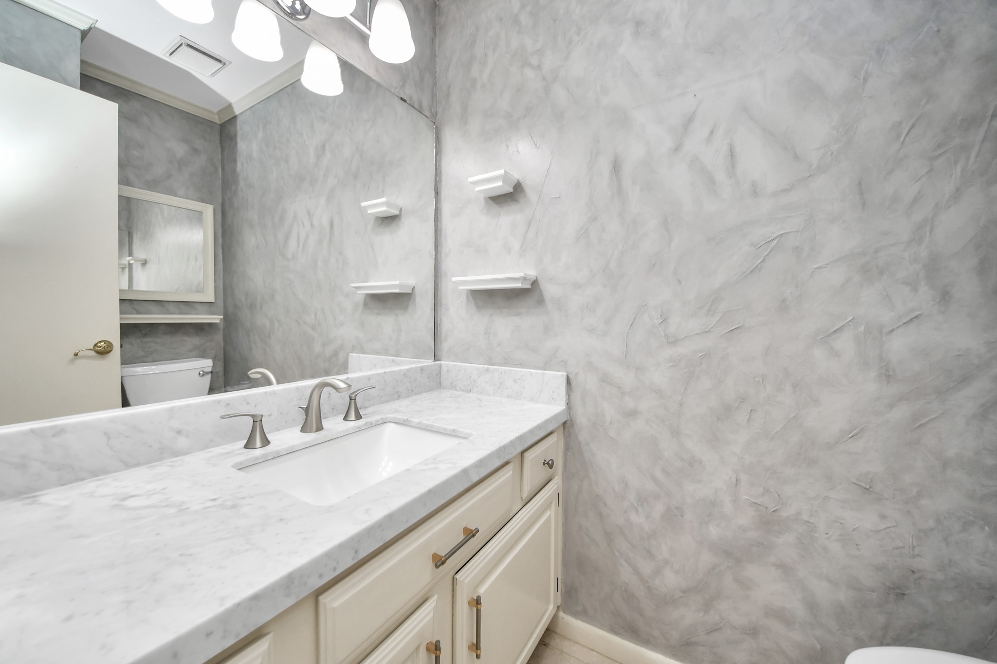 Updated powder bath with marble counters, updated fixtures and clean, neutral finishes.