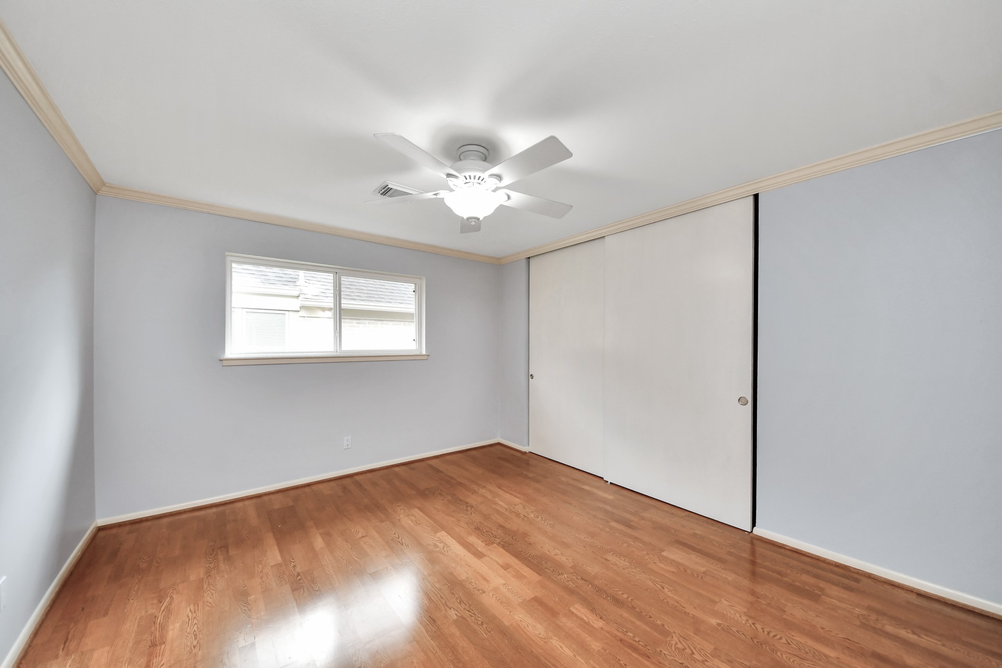 Secondary bedroom with laminate wood flooring, natural light and a generous closet.